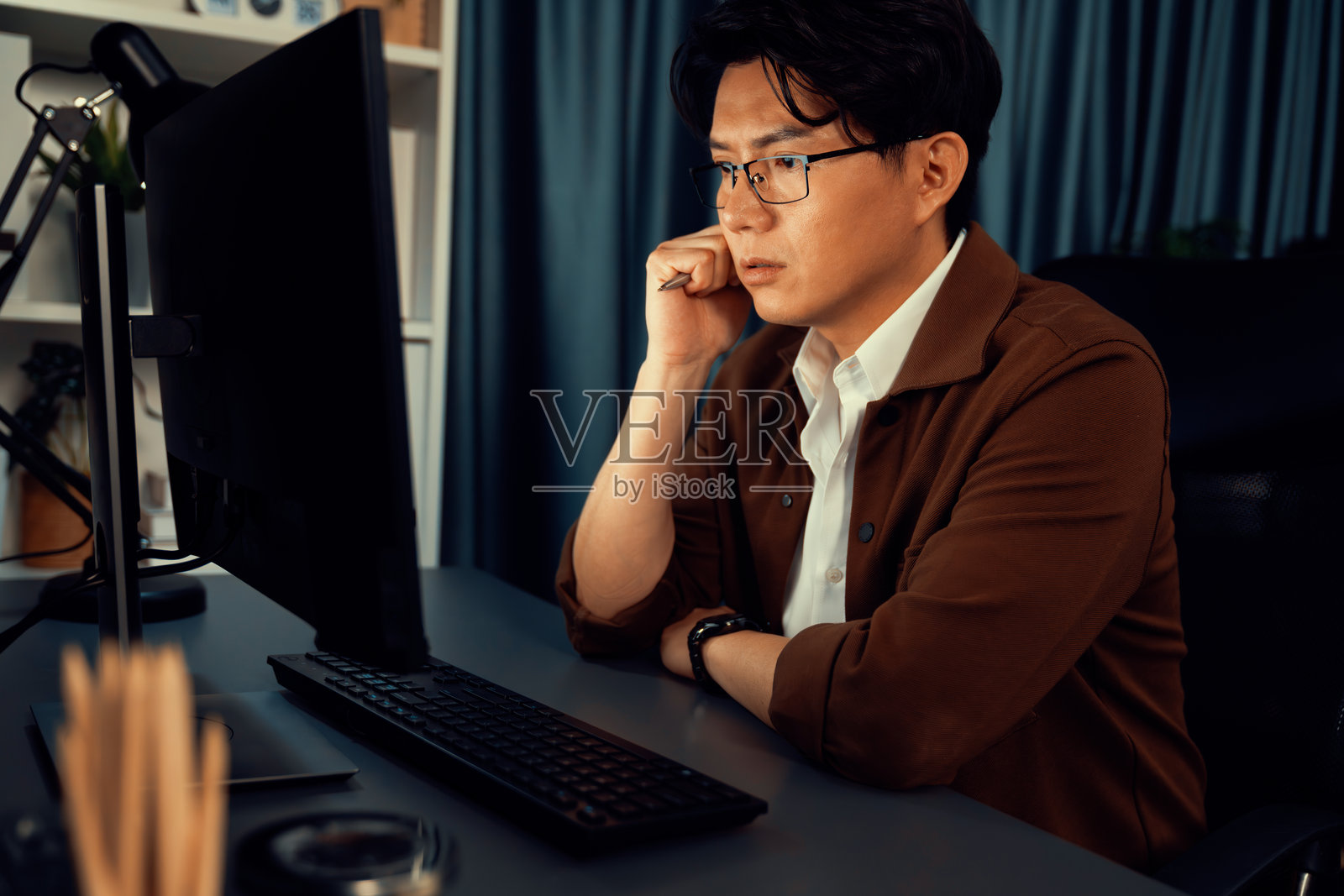 商人深夜专注于计算机商业计划报告。信息高速公路。照片摄影图片