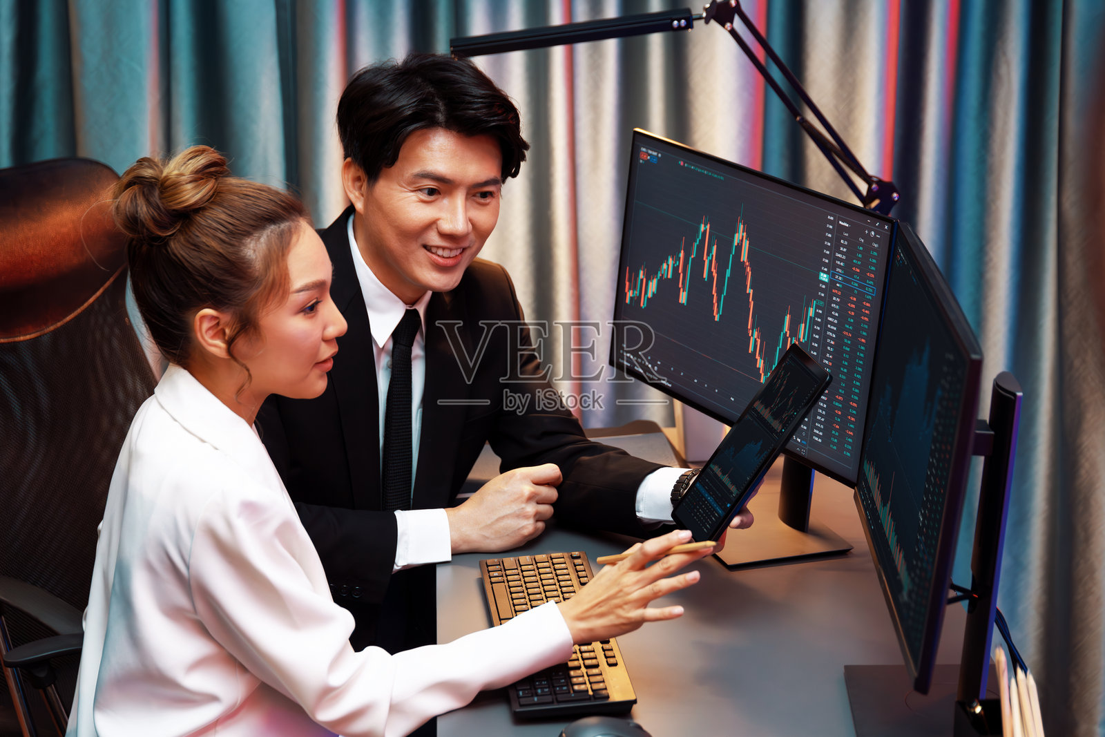 商人手持平板电脑向合作伙伴展示股票信息。信息高速公路。照片摄影图片