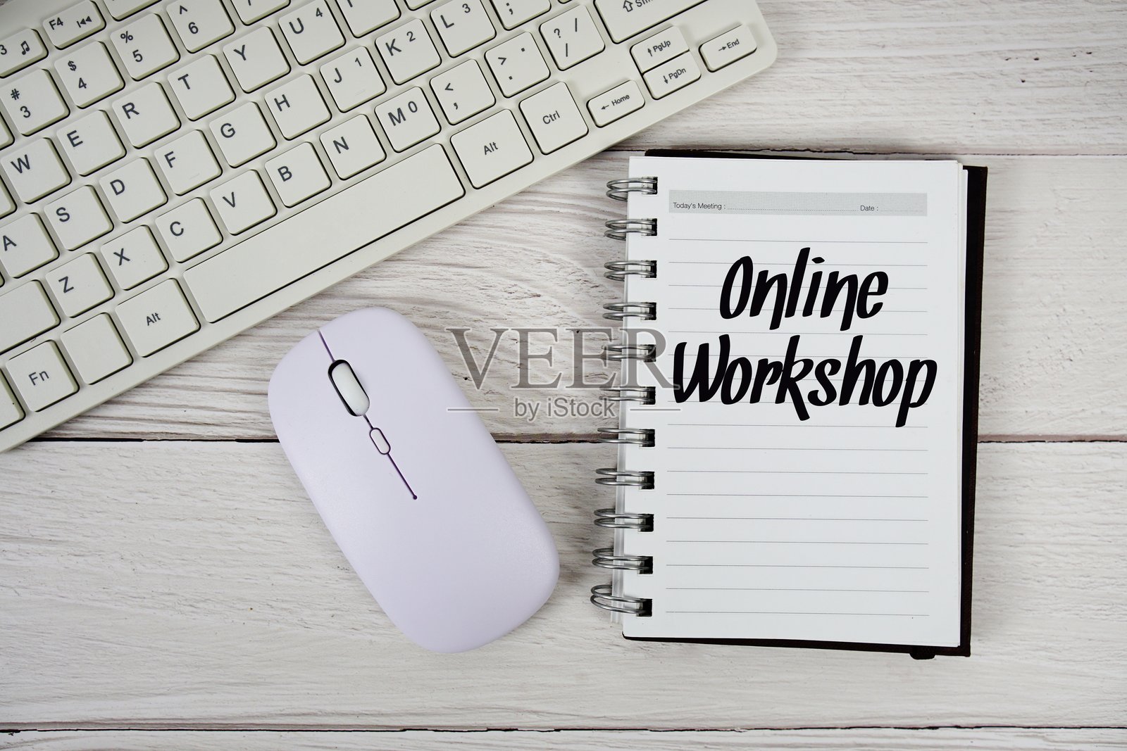 木质背景上的记事本上写着在线研讨会的文字,旁边有键盘和光学鼠标。照片摄影图片