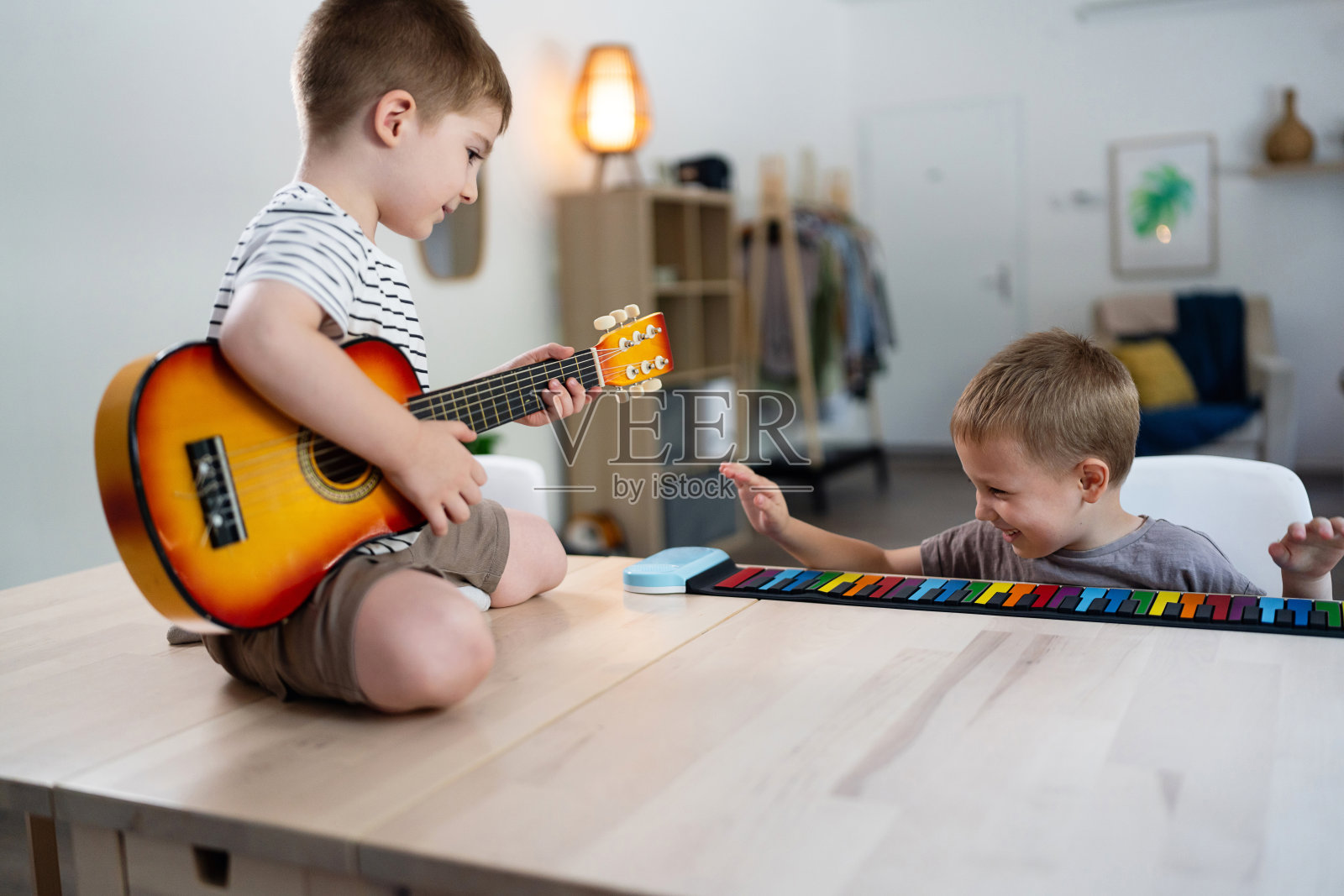两个小兄弟在家一起玩乐器照片摄影图片