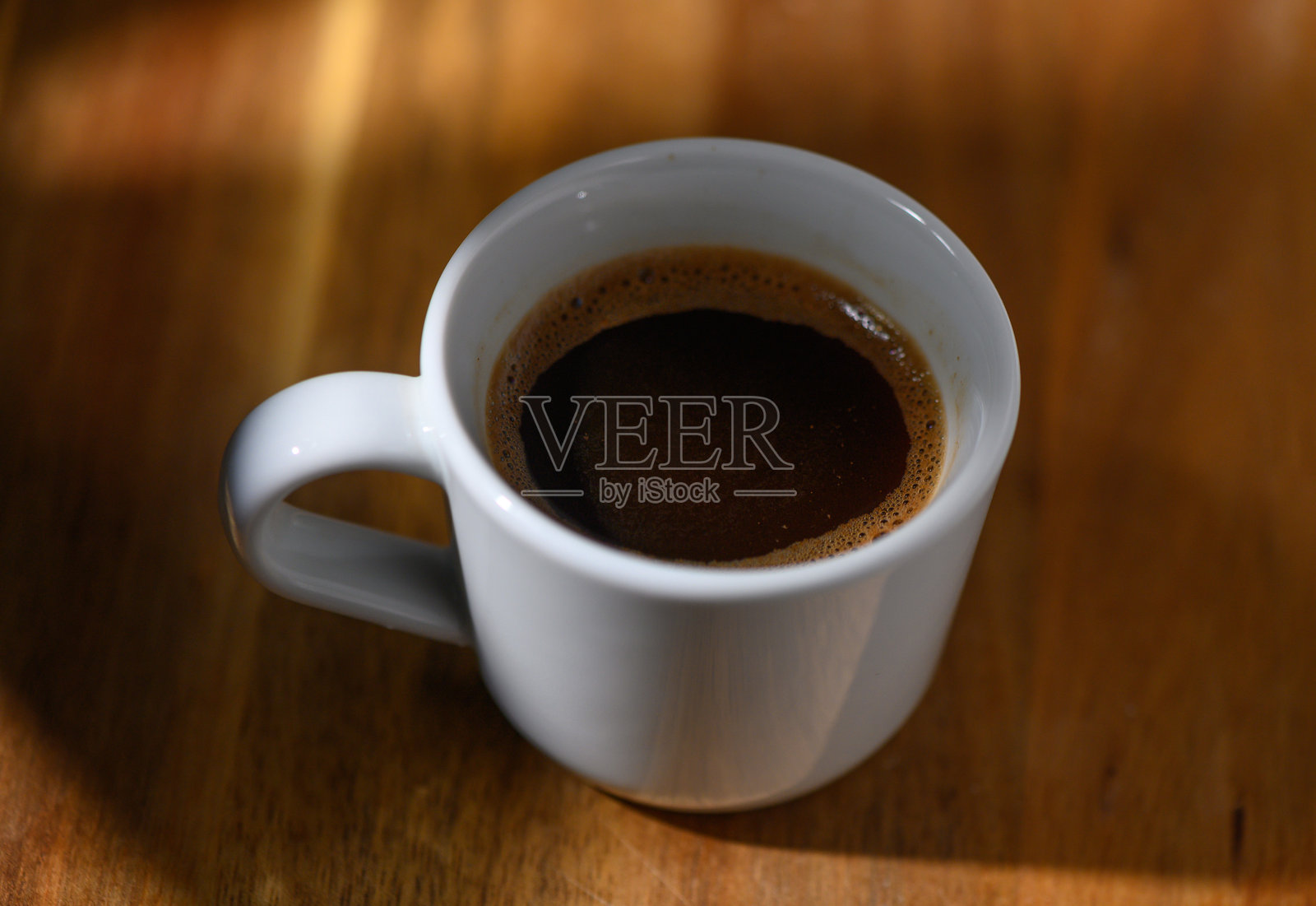 在温馨的环境中享受浓郁的咖啡,阳光透过窗户洒入。照片摄影图片