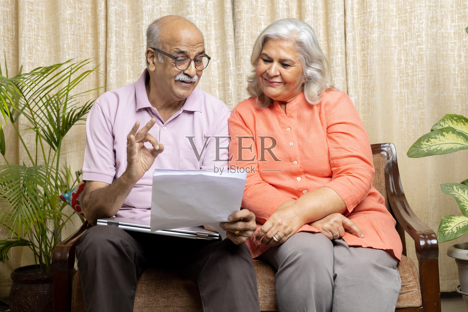 快乐的印度老年夫妇正在查看政策文件并微笑,退休政策封面照片摄影图片