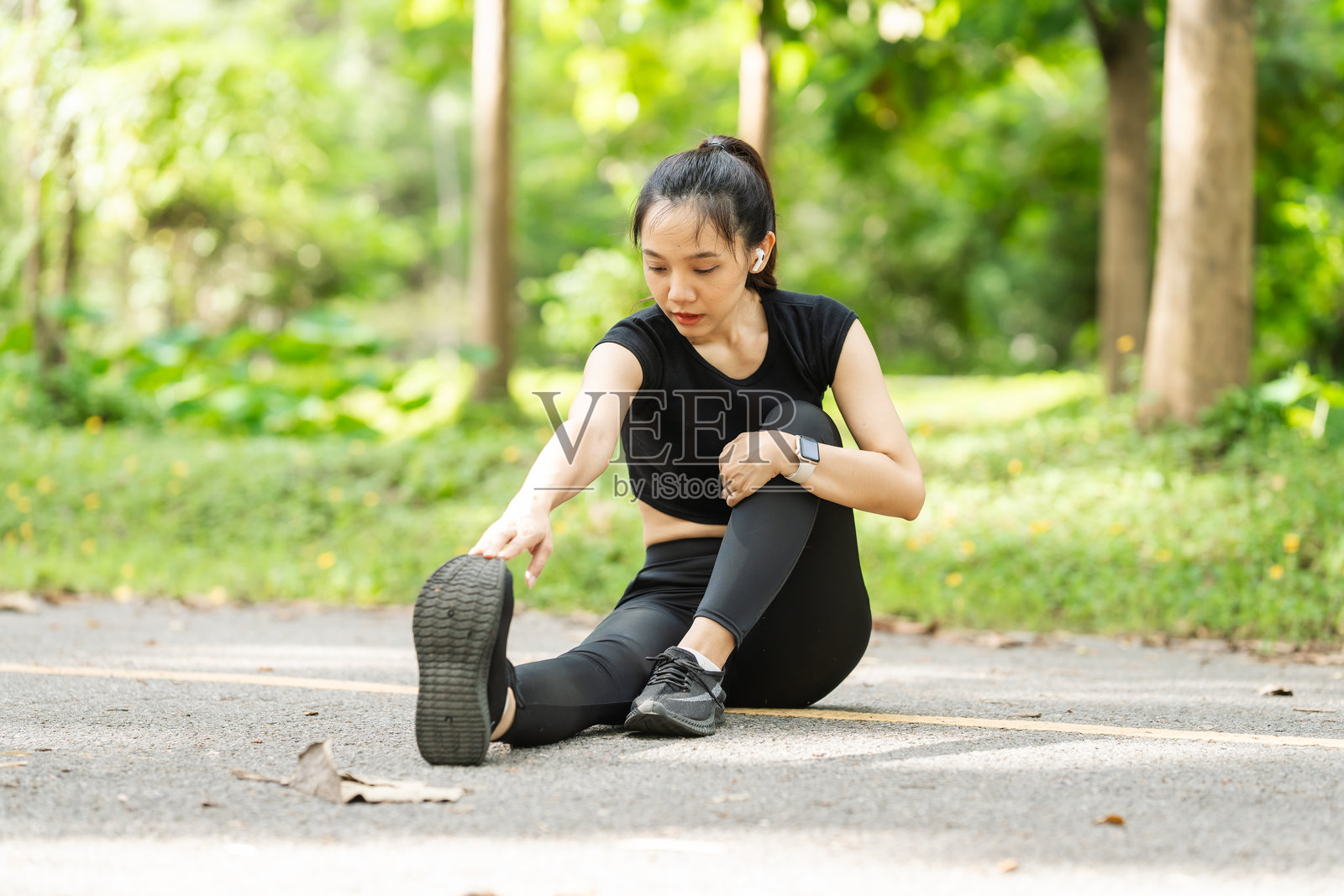 一位穿着运动服的女性在公园里跑步,享受新鲜空气,参与户外活动以保持健康的生活方式,增强心血管健康,感到快乐和充满活力。照片摄影图片