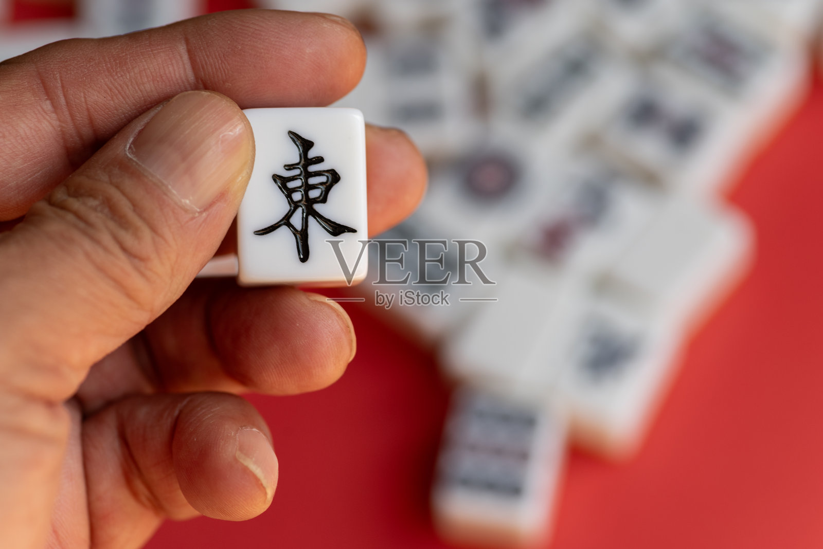 一个人手持麻将牌照片摄影图片