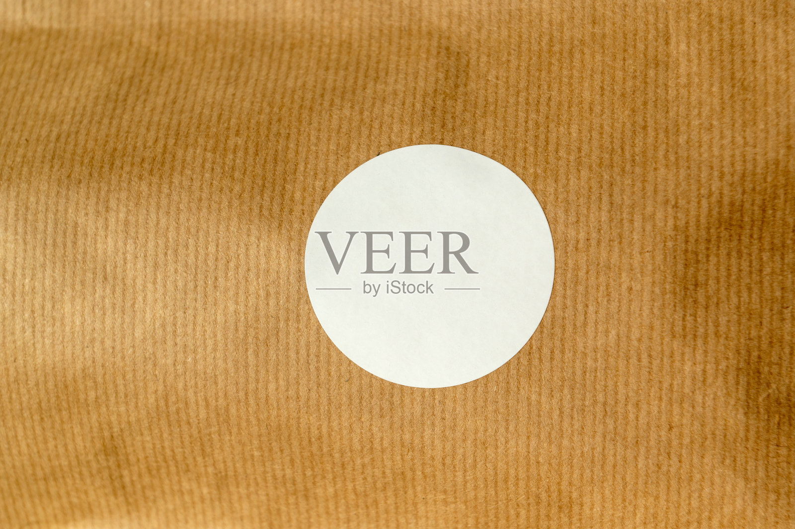 棕色纹理背景上的圆形白色贴纸照片摄影图片