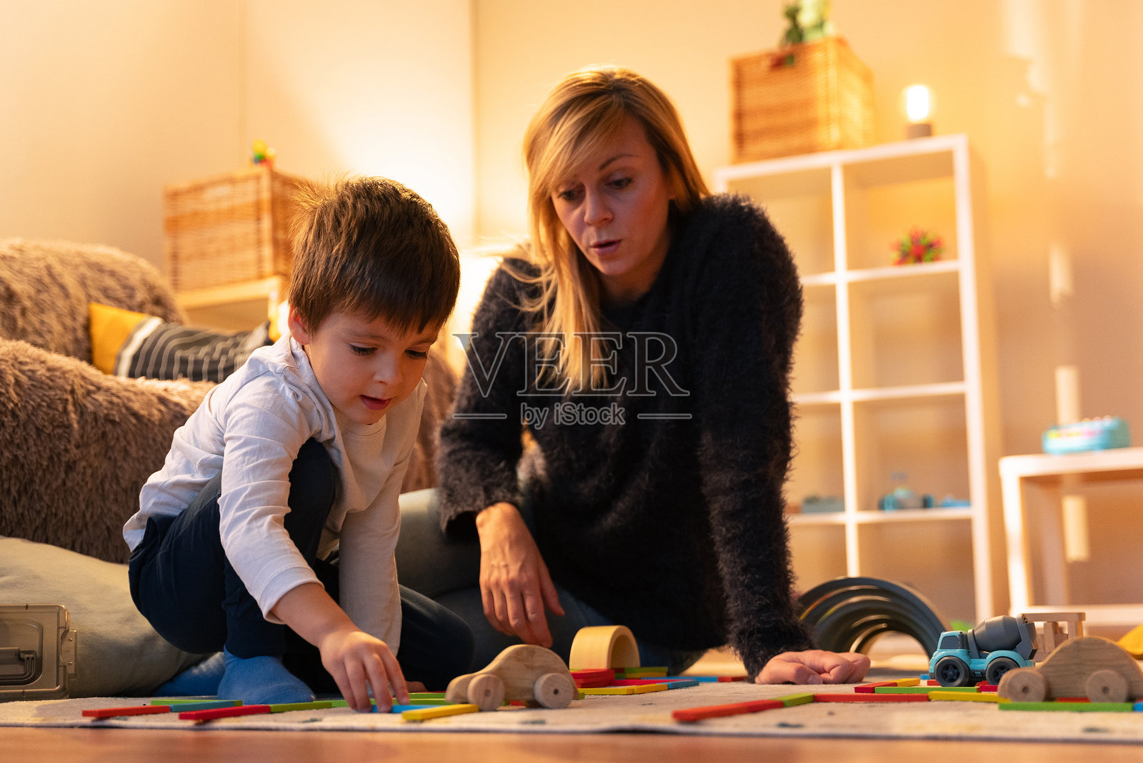 母亲和儿子在地板上玩木制玩具照片摄影图片