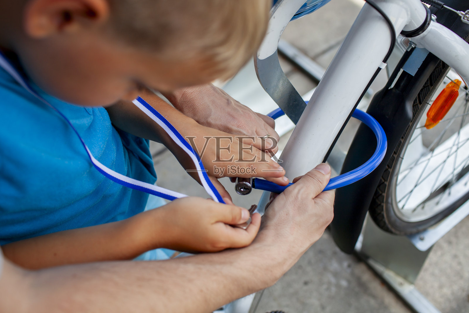 父亲帮助孩子修理自行车,展现了团队合作和动手学习的精神照片摄影图片