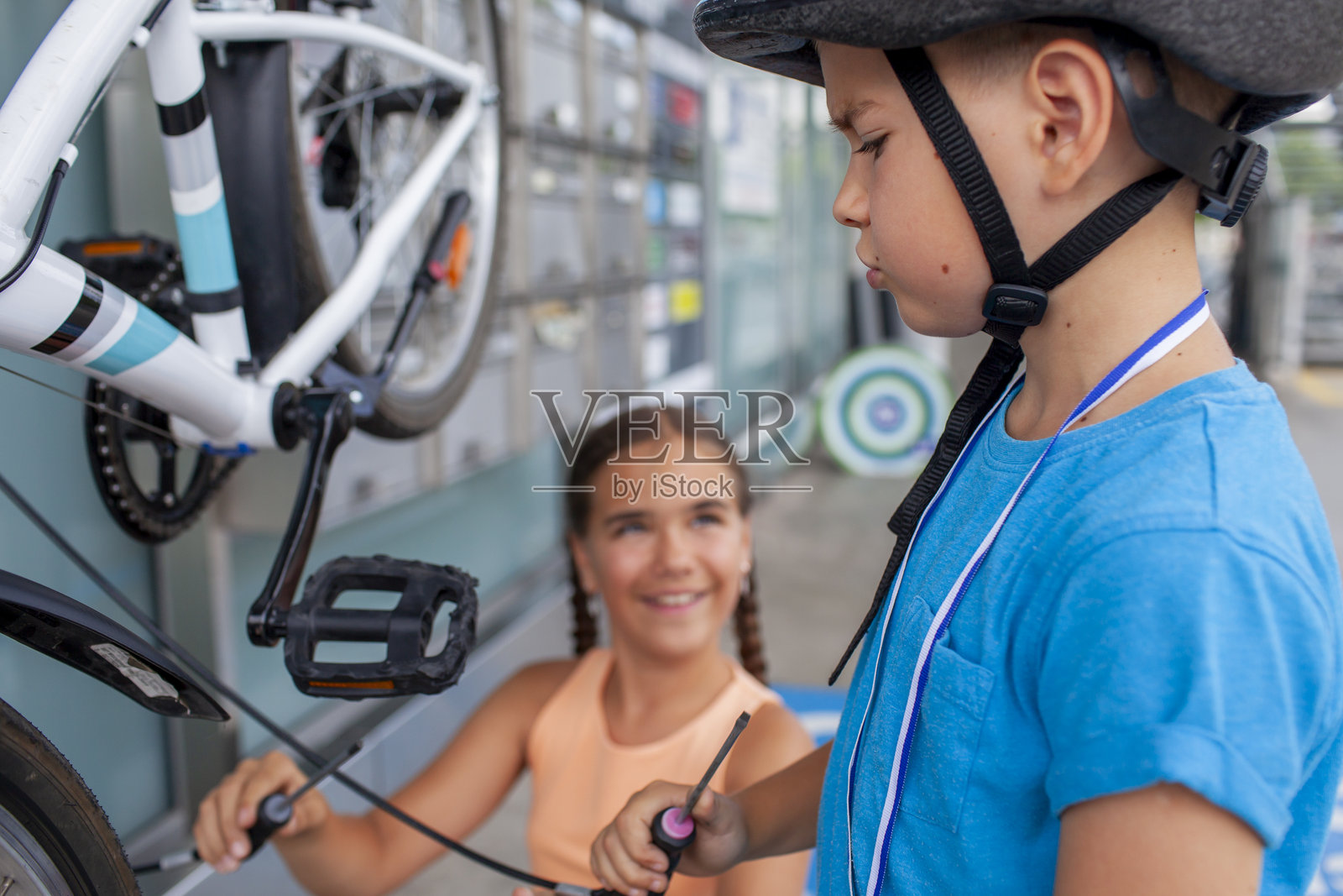 父亲帮助孩子修理自行车,展现了团队合作和动手学习。照片摄影图片