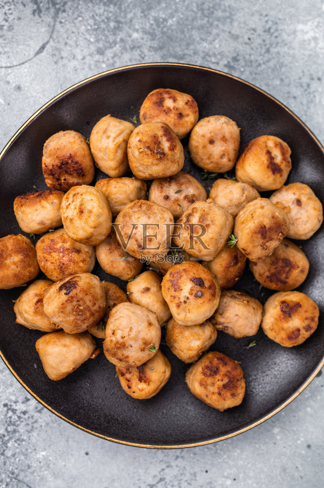 美味的肉丸,肉饺子上点缀着新鲜的香草。是任何餐点的美妙补充,为餐桌带来温暖和满足感。灰色背景。俯视图。照片摄影图片