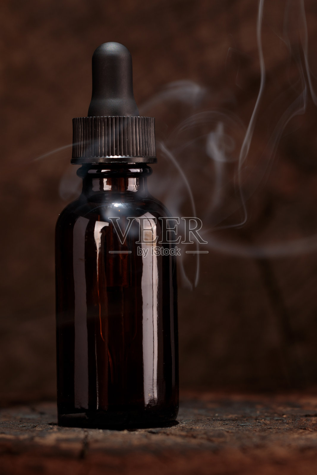带有烟雾效果的深琥珀色滴管瓶照片摄影图片