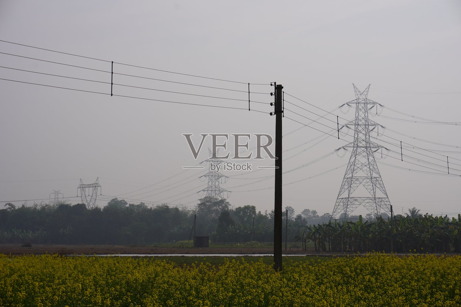 电力塔与田野上的高压电线相连照片摄影图片