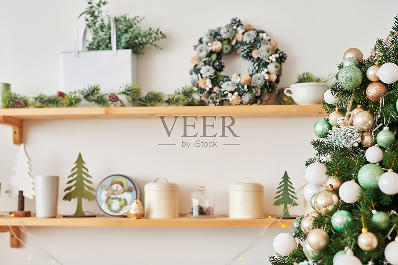 厨房里的圣诞装饰。圣诞餐具。圣诞烹饪用具。明亮的新年厨房内部。新年贺卡模板。白色薄荷色厨房。厨房里的圣诞树。照片摄影图片