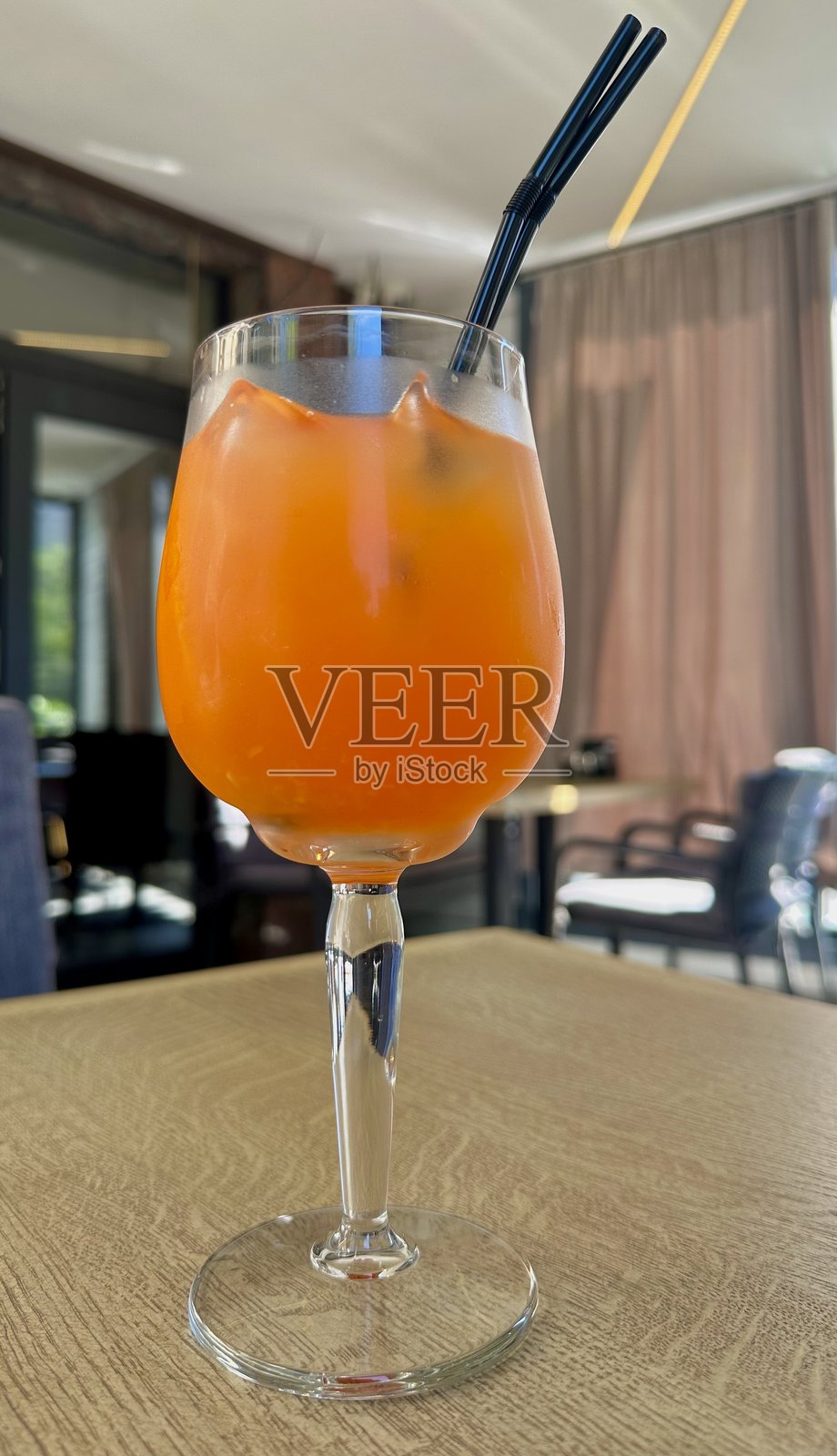 鲜艳的橙色鸡尾酒在水晶杯中,冰镇后散发出优雅和夏日清爽感照片摄影图片