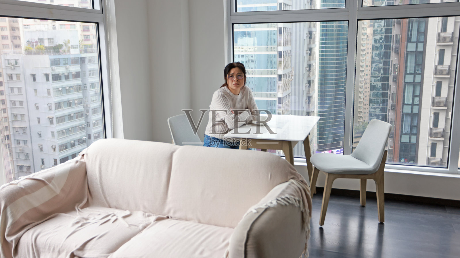 女人收到坏消息,坐在窗边。照片摄影图片