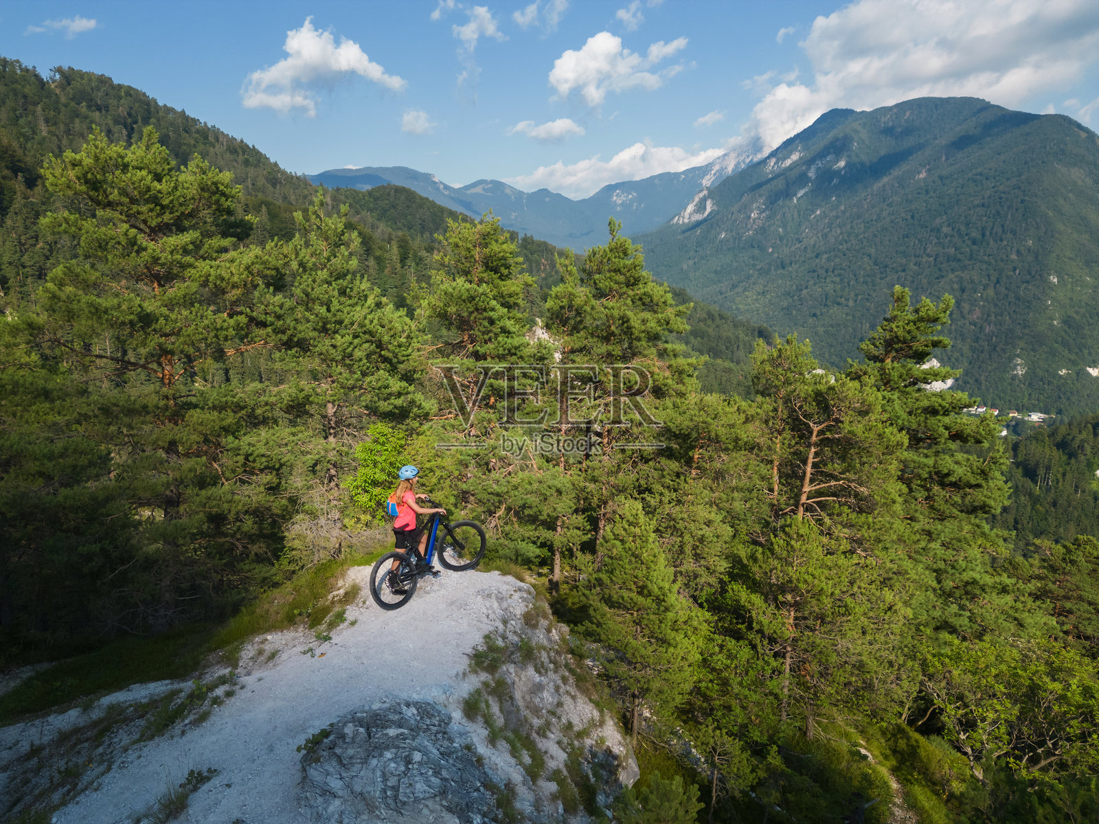 女性骑士在白色石子小径上骑行电动山地自行车照片摄影图片