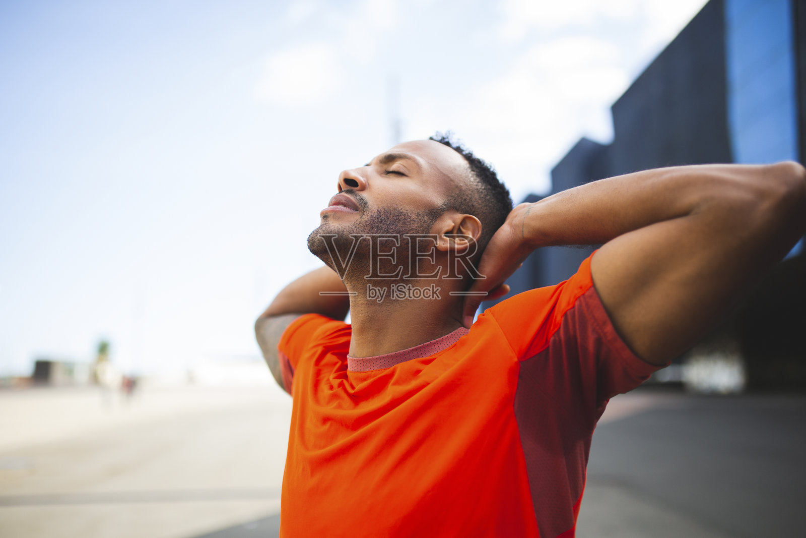 运动员双手放在头后,闭眼伸展身体照片摄影图片