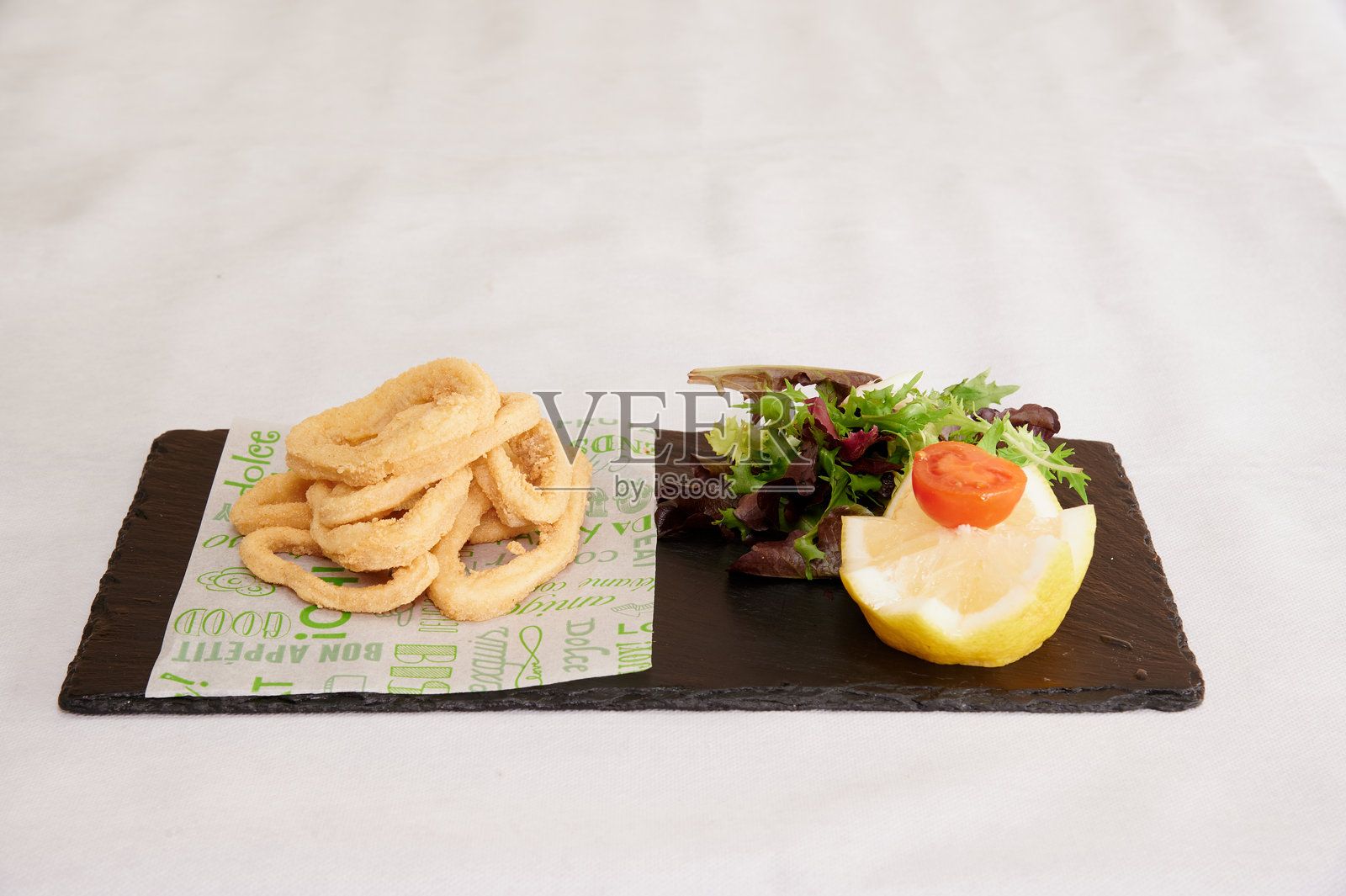 一盘食物,上面放着一片柠檬。照片摄影图片