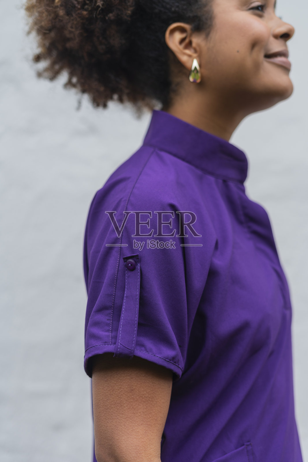 快乐的拉丁美洲女佣在酒店工作,手里拿着毛巾,微笑着看向镜头。照片摄影图片