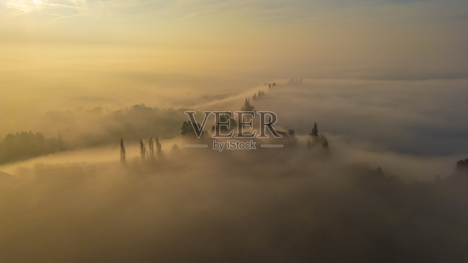 雄伟的教堂笼罩在晨雾中,伴随着日出照片摄影图片