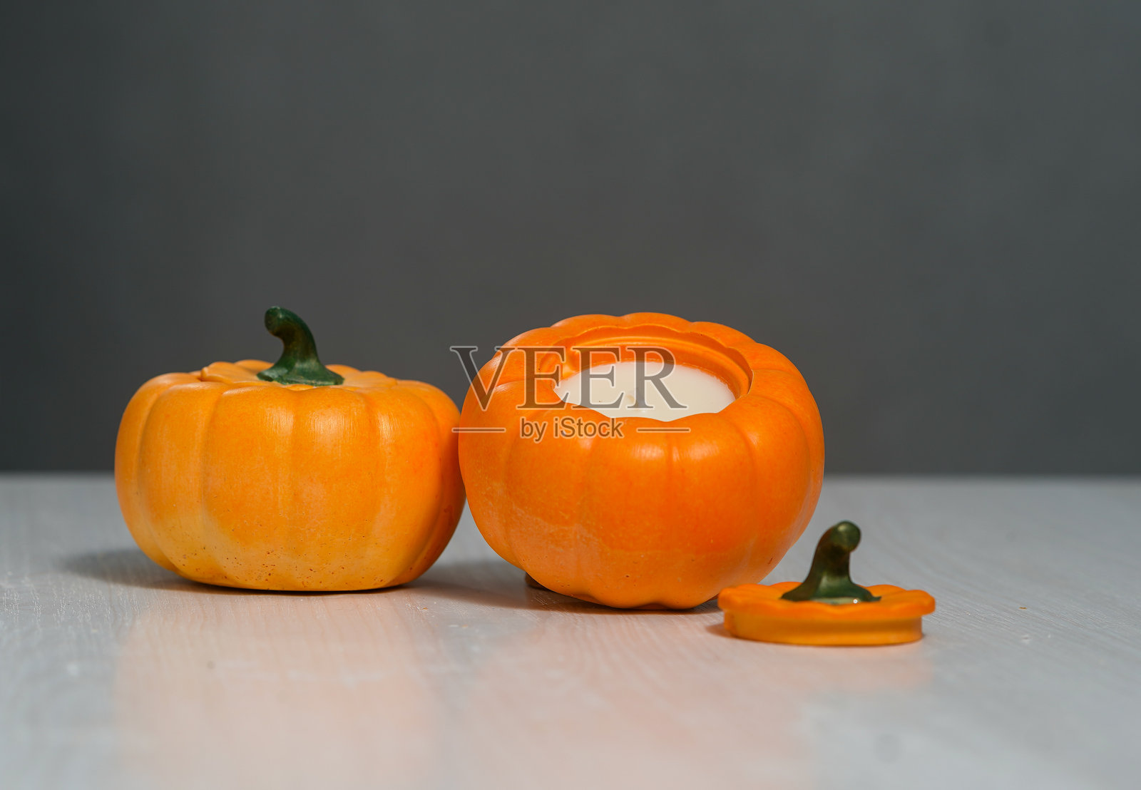 灰色背景上的橙色南瓜形状手工蜡烛照片摄影图片