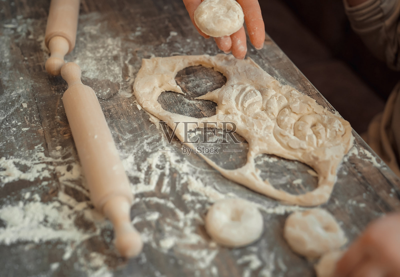 孩子在家用饼干模具切饼干,并玩面粉。照片摄影图片