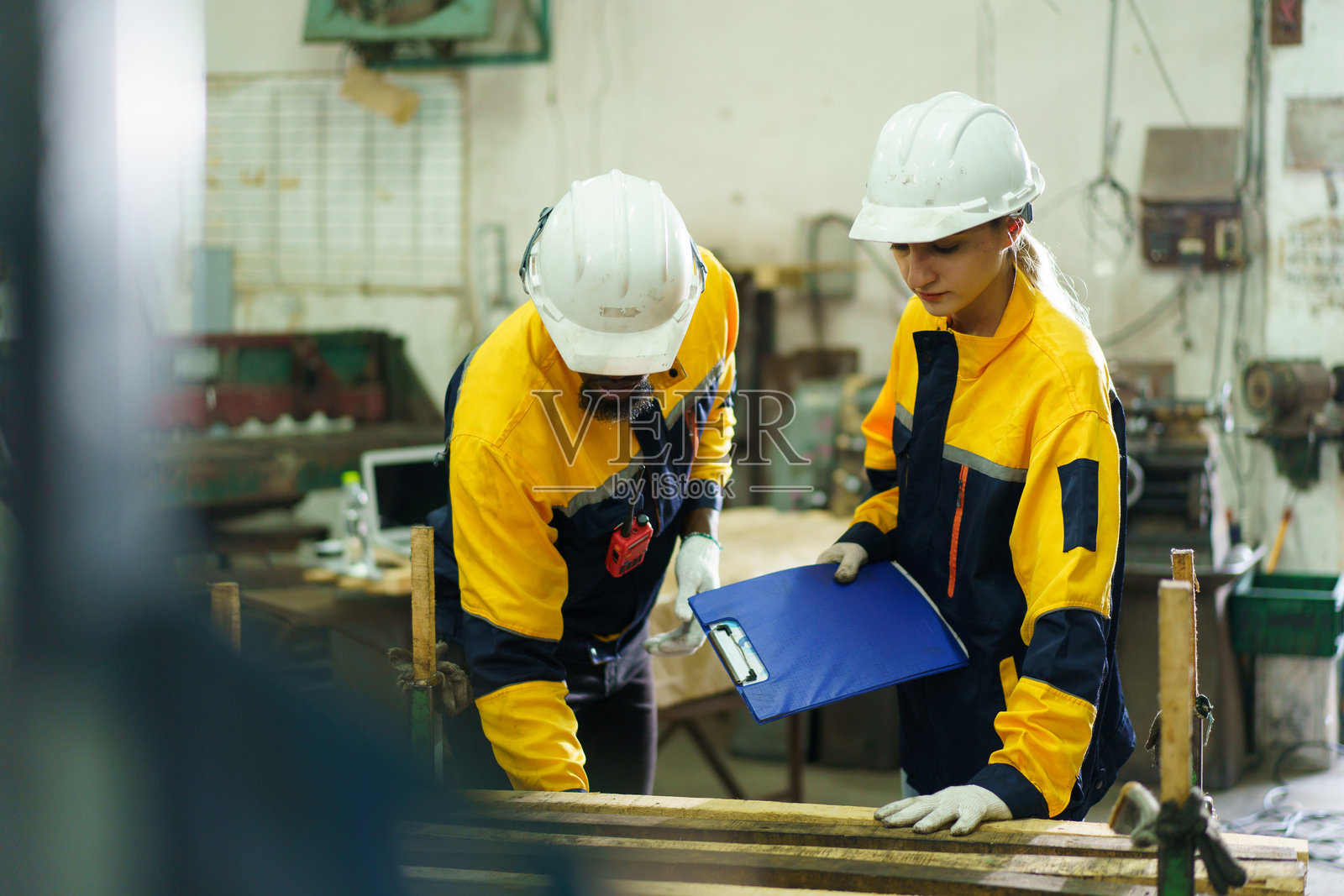 机械工程师团队正在工厂的车间对重型机器进行检查。照片摄影图片