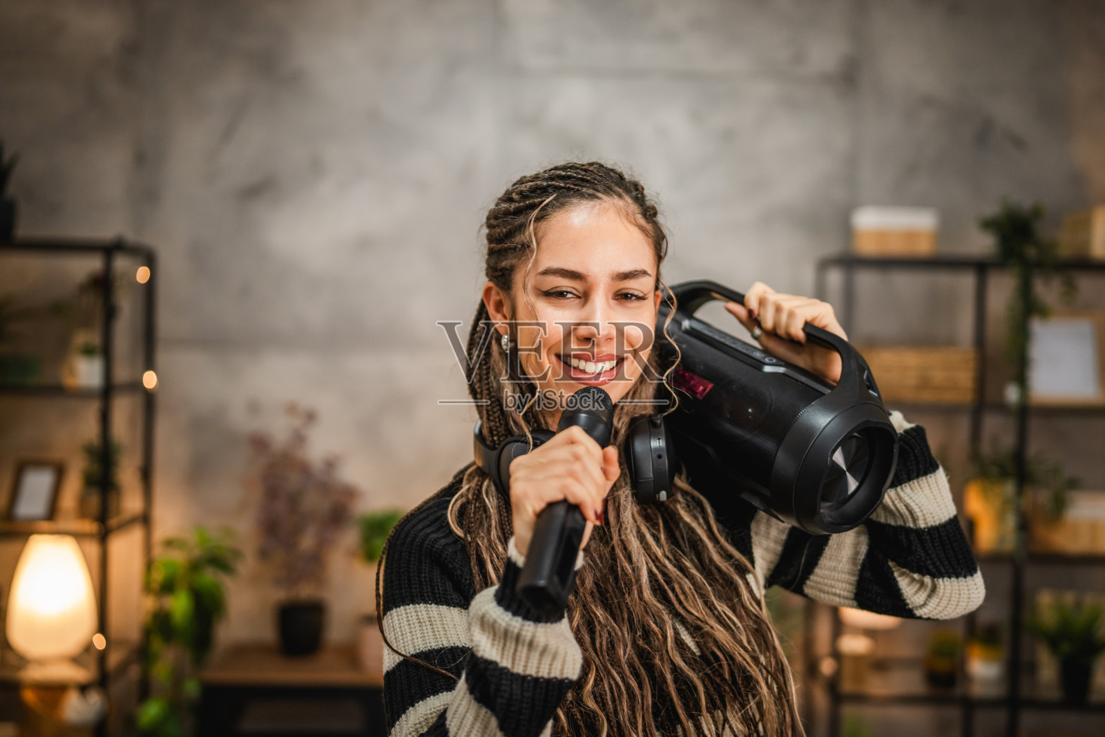 快乐的年轻女性在音响前跳舞、听音乐并唱歌照片摄影图片