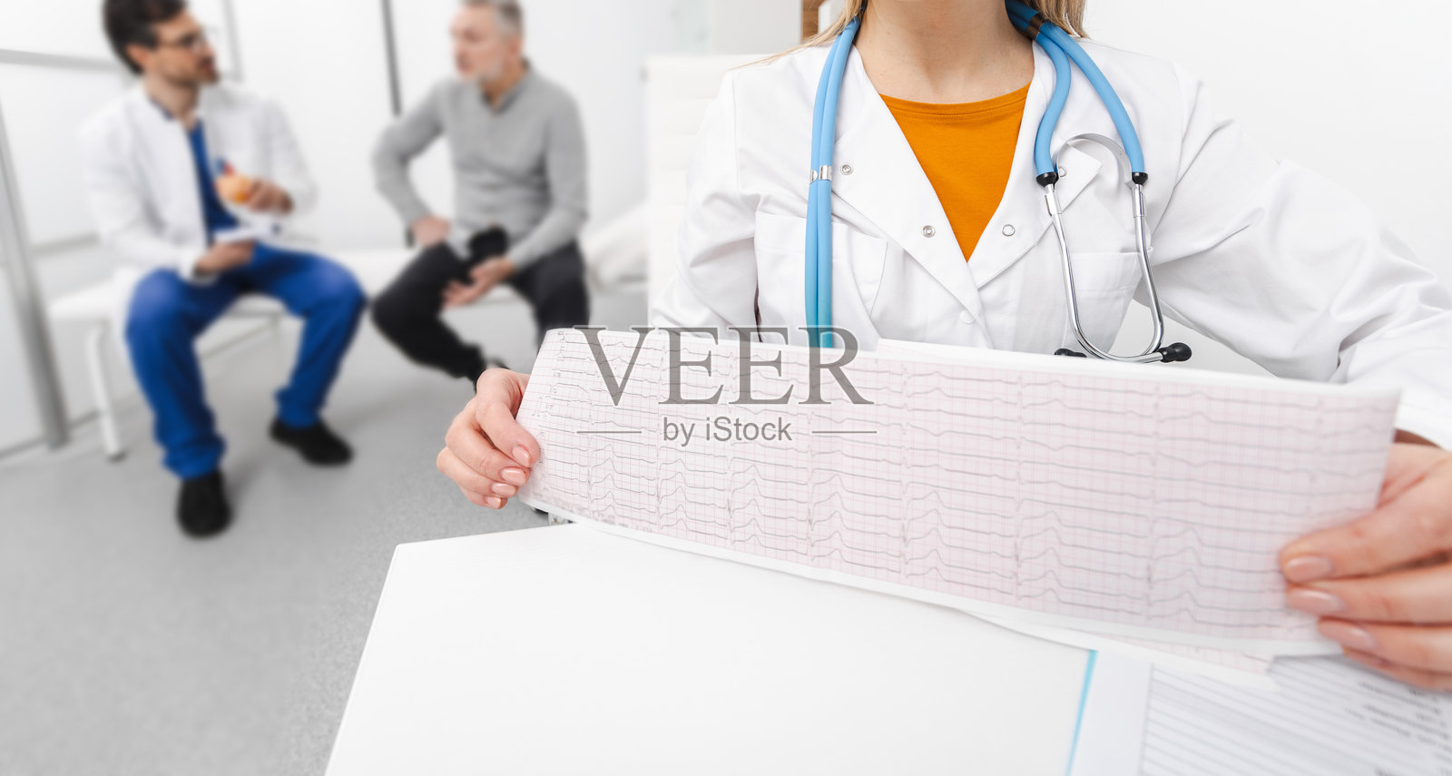 医生手中拿着心电图测试结果,进行心脏病咨询。ECG,EKG照片摄影图片