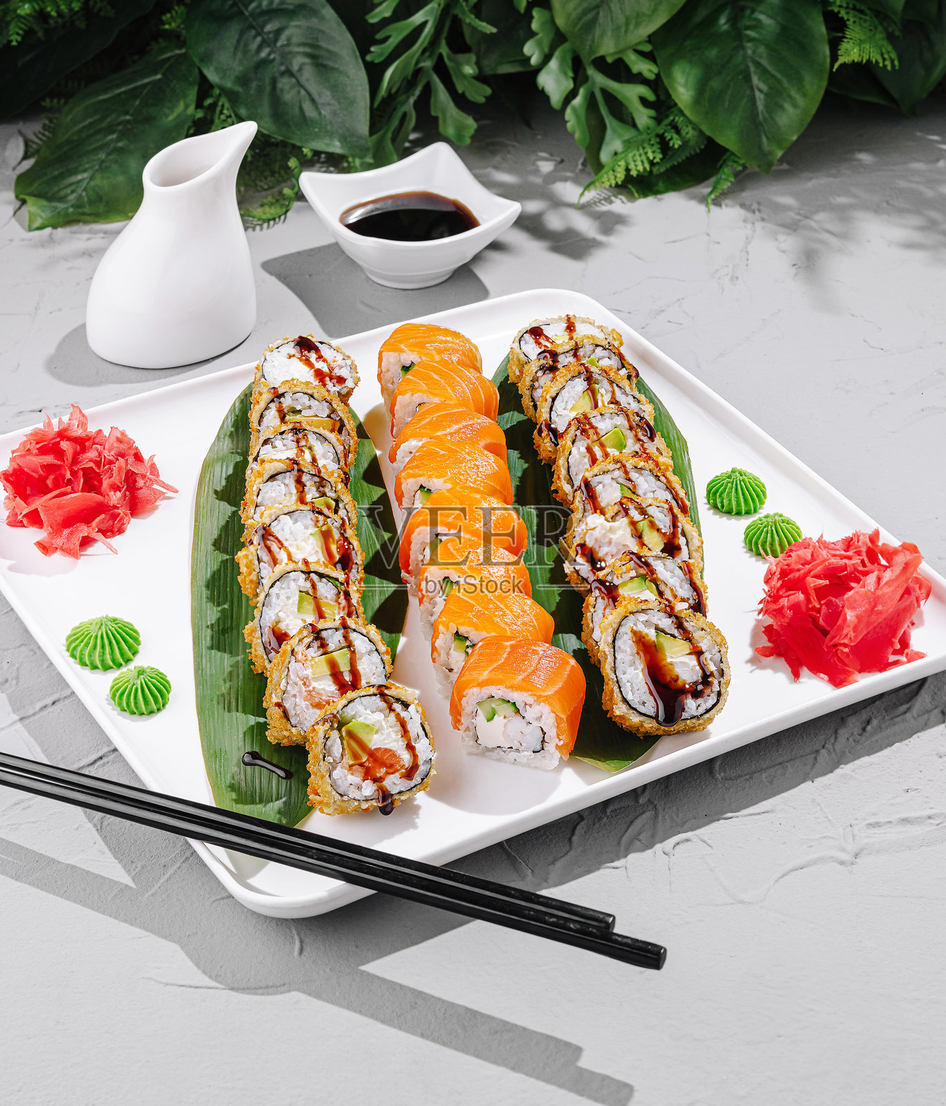 美味的寿司卷优雅地摆放在宁静的环境中,配有芥末和姜。照片摄影图片