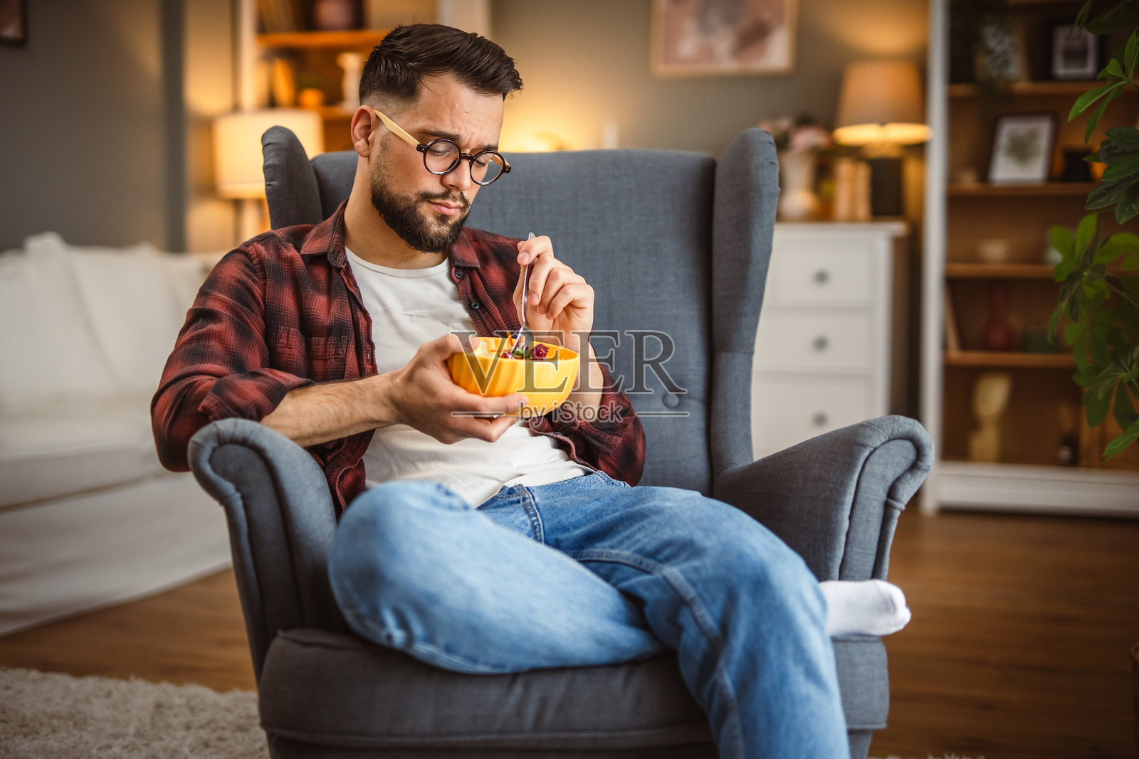 成年男子坐在扶手椅上吃沙拉,健康生活方式概念照片摄影图片