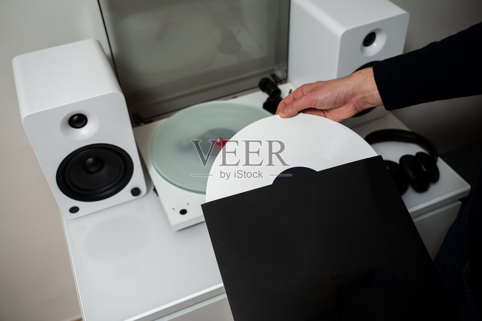 现代唱针播放器上的黑胶唱片。音乐家将黑胶唱片更换到唱盘播放器和音响系统上。照片摄影图片