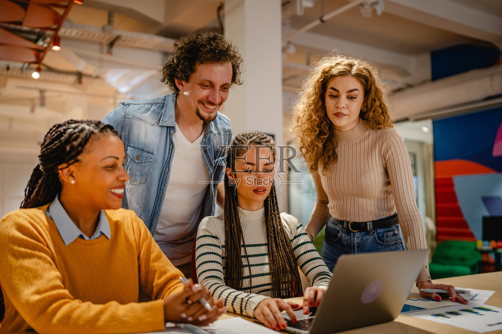 男女同事在办公室一起使用笔记本电脑进行研究照片摄影图片