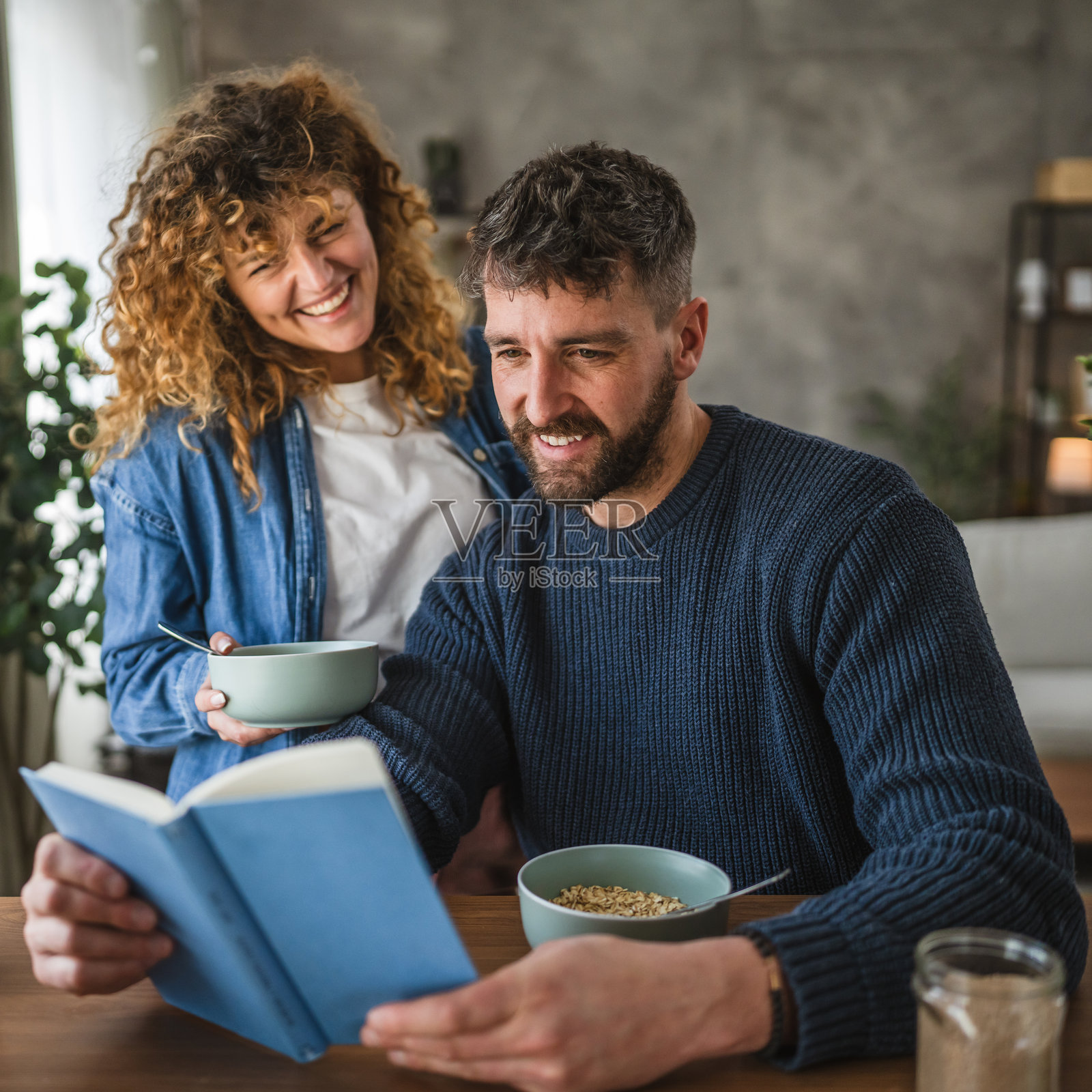 男朋友和女朋友在家里早餐时一起阅读书籍照片摄影图片