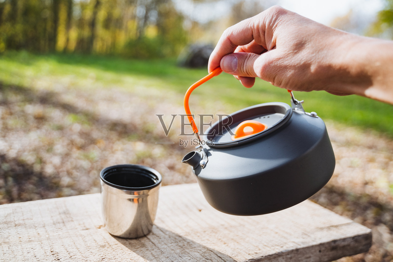 当我小心翼翼地将热腾腾的水从露营壶倒入金属杯时,我停下来欣赏大自然的美丽景色。照片摄影图片