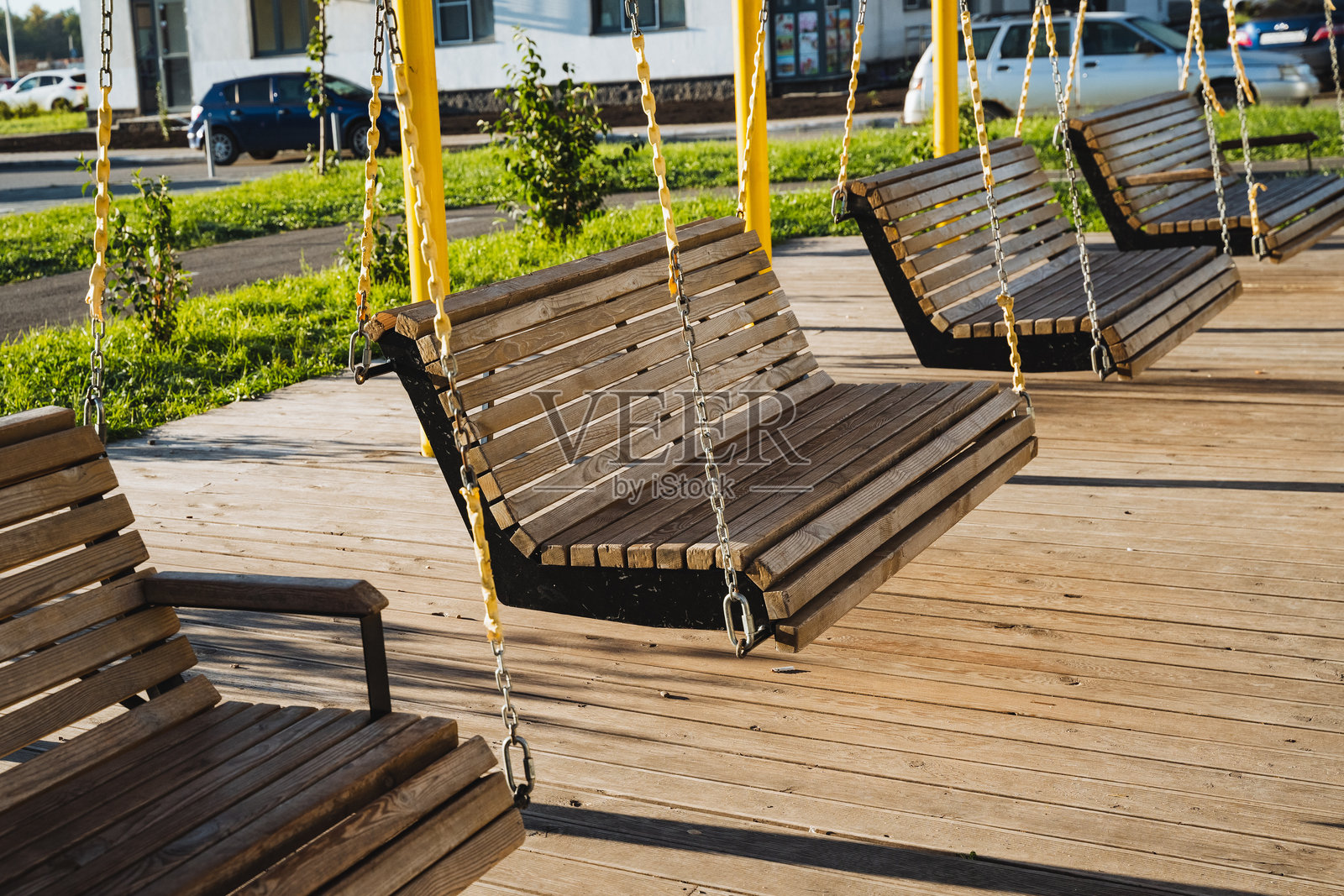 一排精美排列的迷人木秋千优雅地摆放在美丽的木甲板上,吸引人们在极致的舒适和时尚优雅中享受户外时光。照片摄影图片