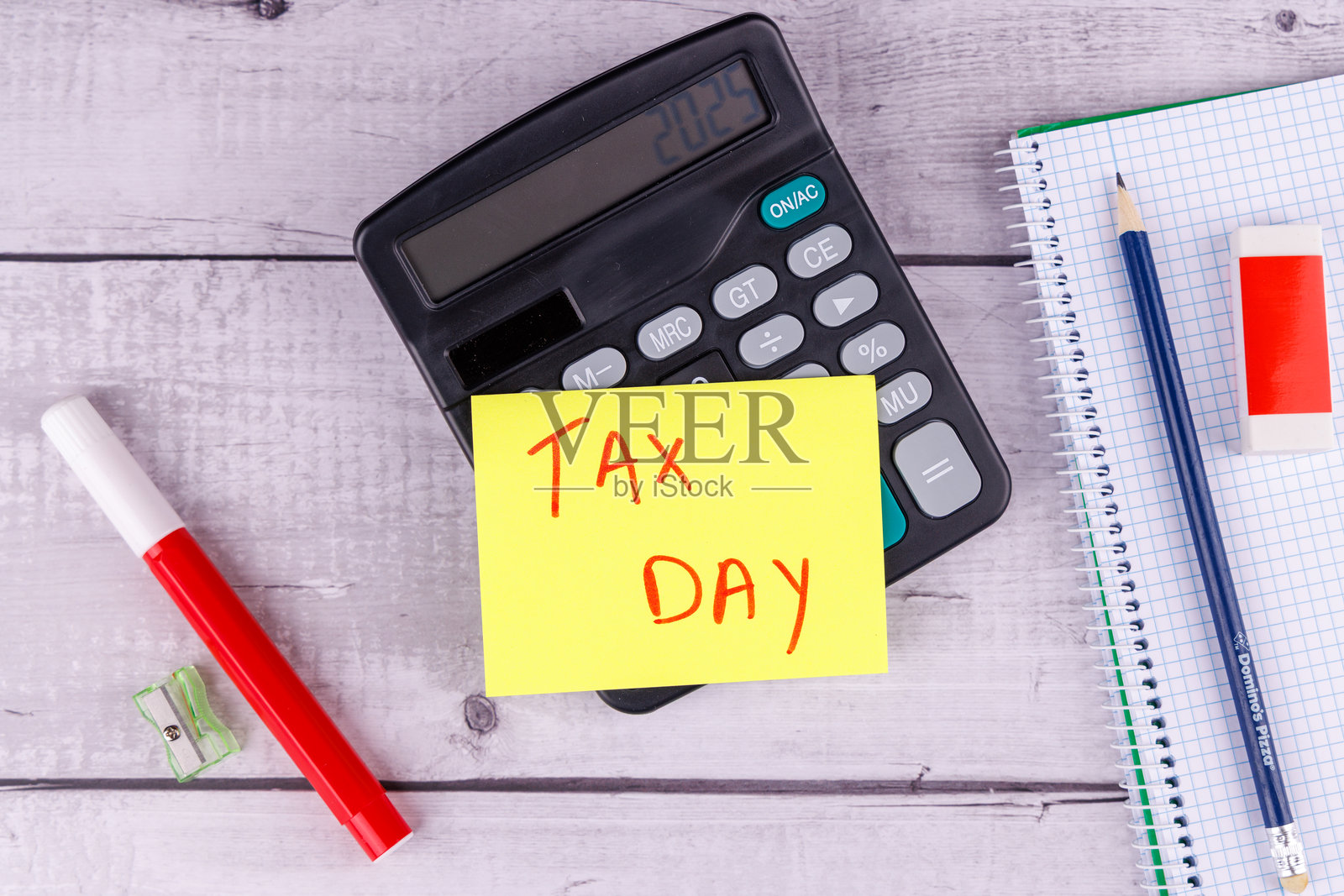 税务准备场景,白色木桌上有一个日历,4月15日被标记,1099税表,一个计算器和一支铅笔。照片摄影图片