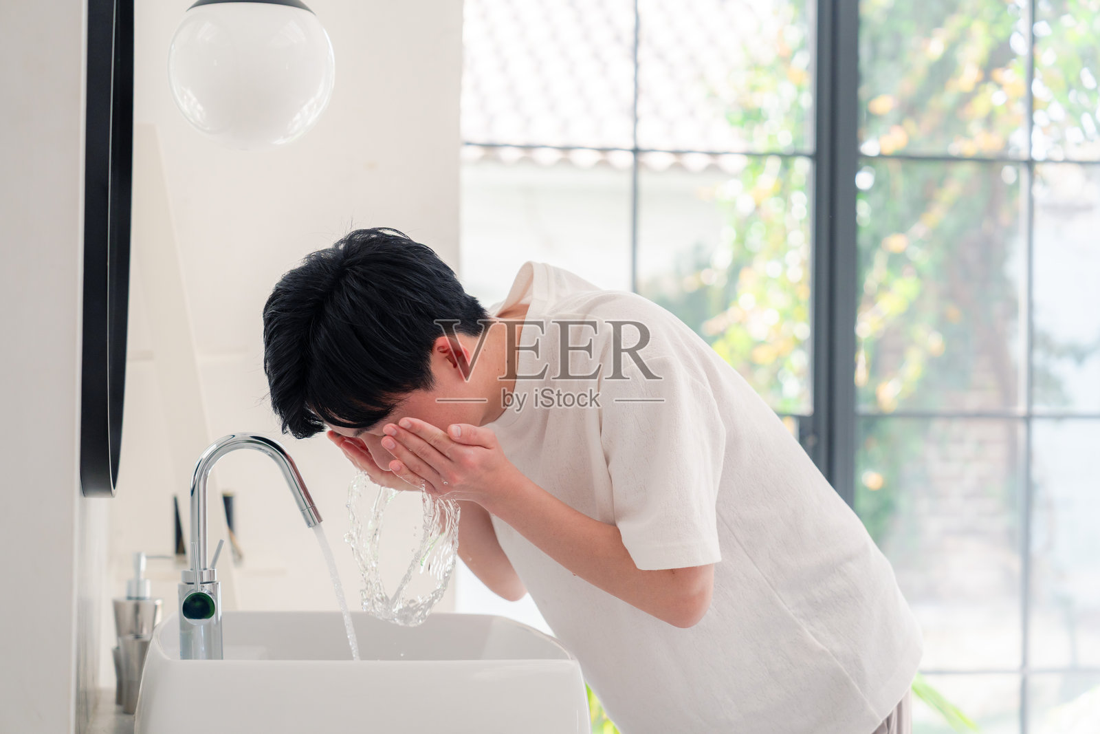 年轻男子在洗手间洗脸照片摄影图片