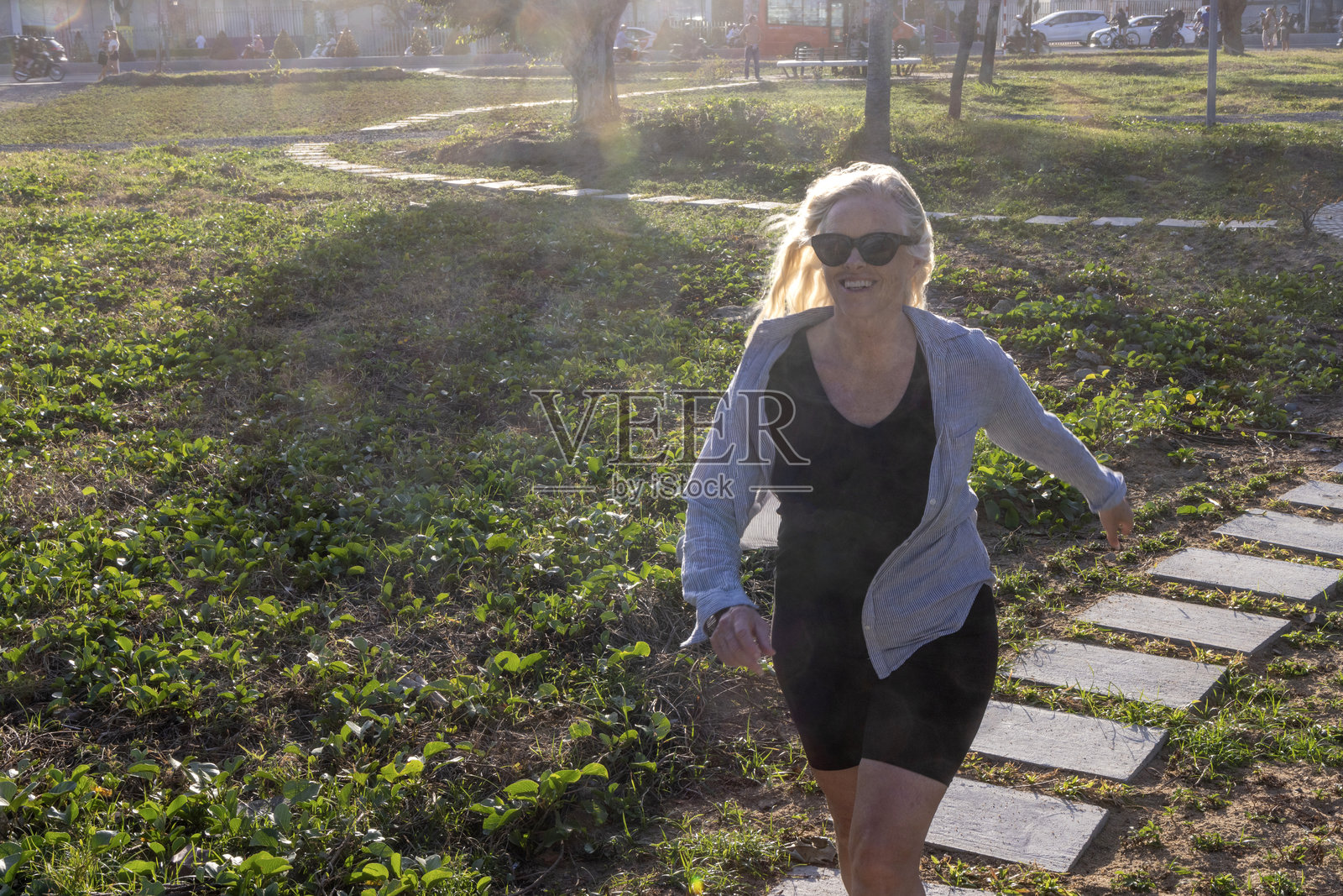 成熟的女性在铺路石之间跳跃照片摄影图片
