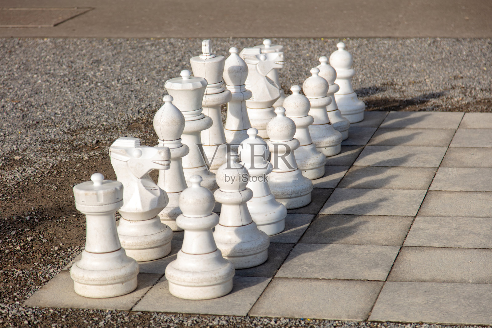 户外的国际象棋棋盘,配有大型棋盘和大号白色棋子照片摄影图片