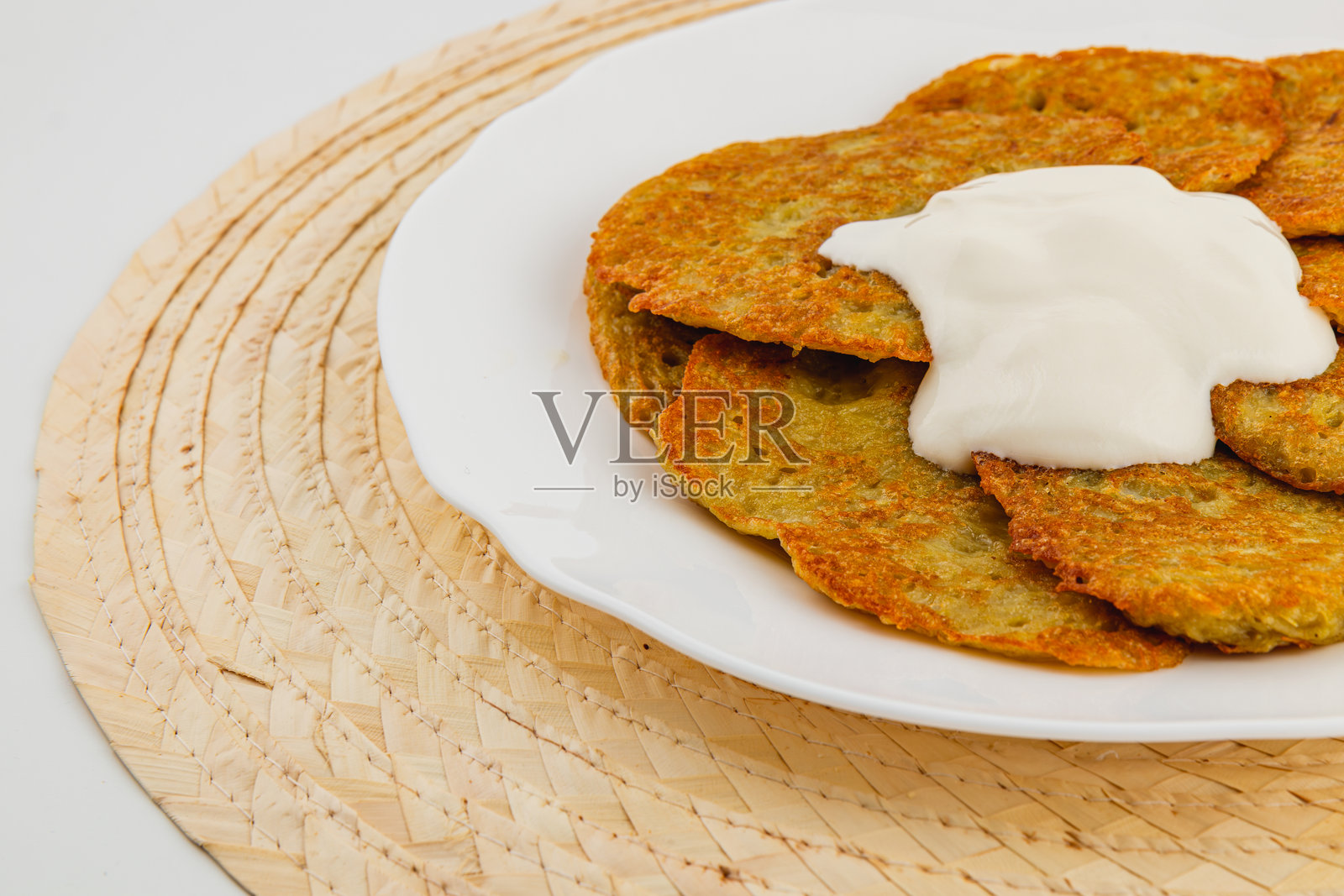 美味的土豆煎饼配上奶油蘸酱,摆放在编织的餐垫上照片摄影图片
