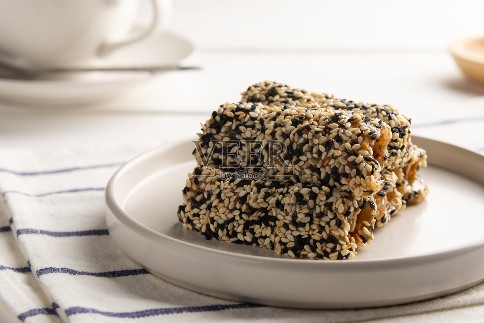 黑色烤芝麻和花生用糖粘合在一起,形成美味的芝麻糖。照片摄影图片