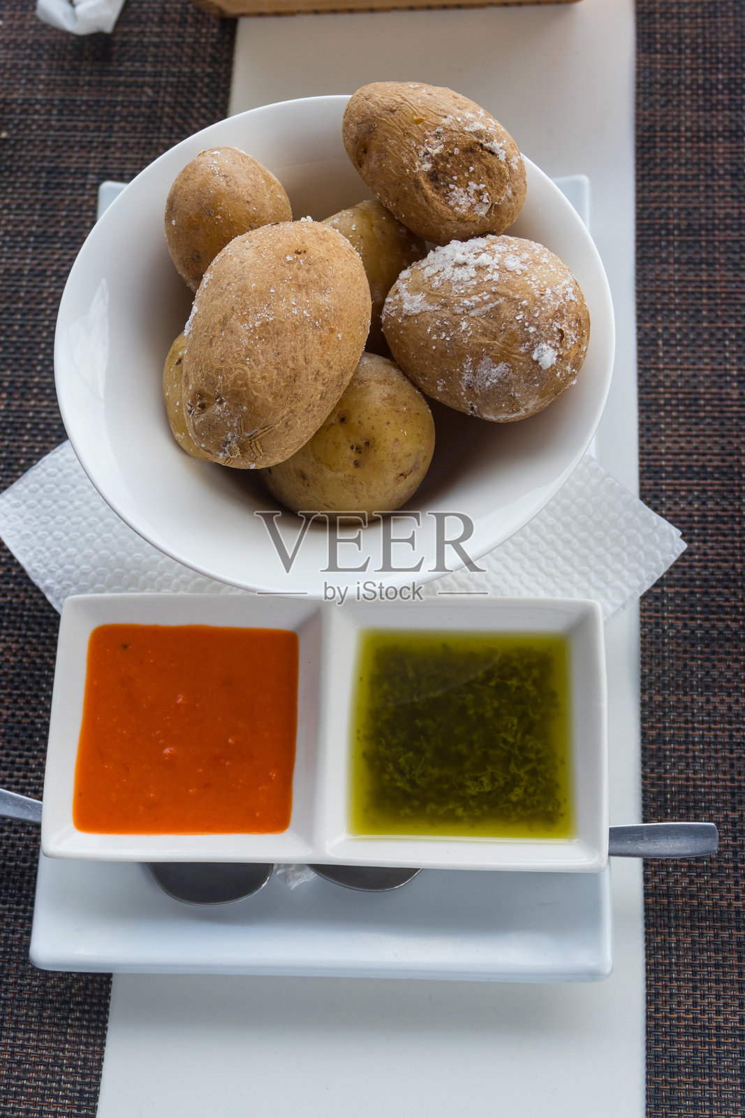 加那利土豆(papas arrugadas)配红绿莫霍酱。加那利群岛的典型菜肴。照片摄影图片