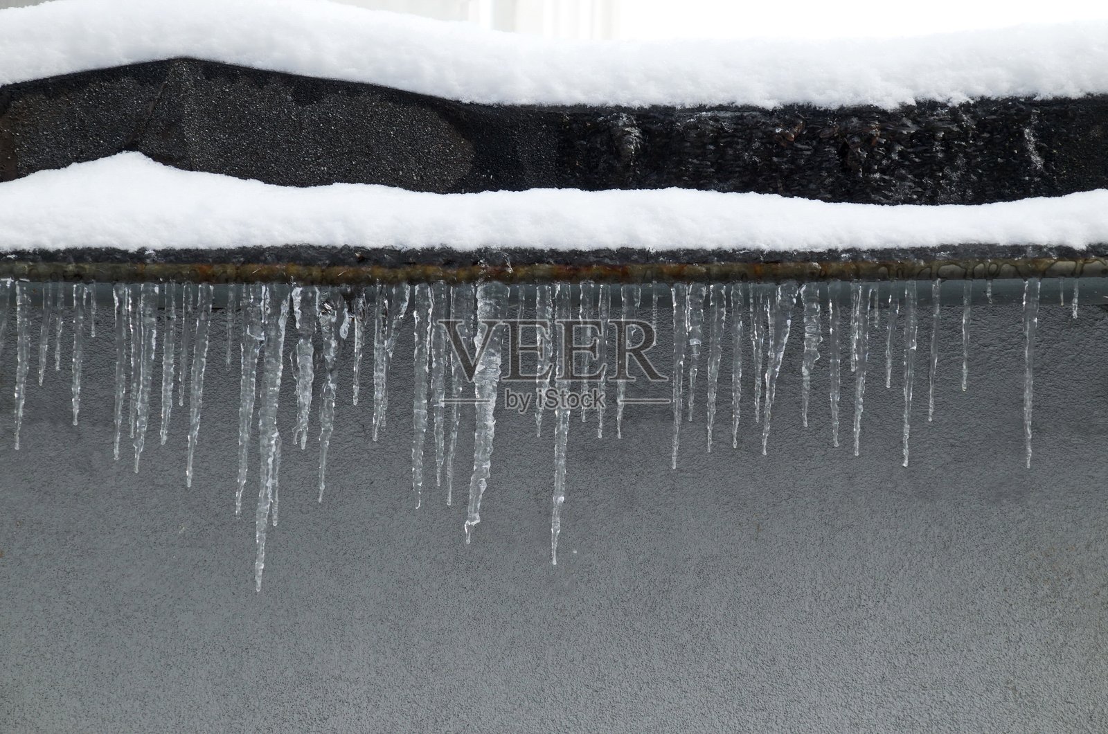 冬季索非亚,一栋建筑的一部分,屋顶悬挂着晶莹剔透的冰柱。照片摄影图片