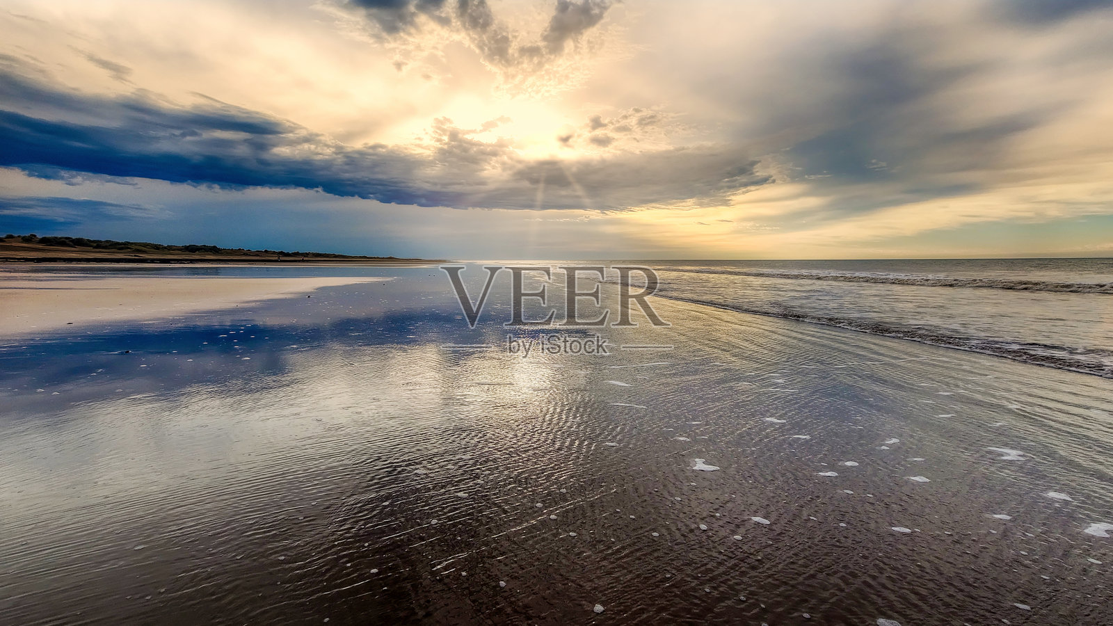 宁静的海滩场景,温柔的波浪映衬着金色的日落,非常适合夏季假期和旅行主题项目。照片摄影图片