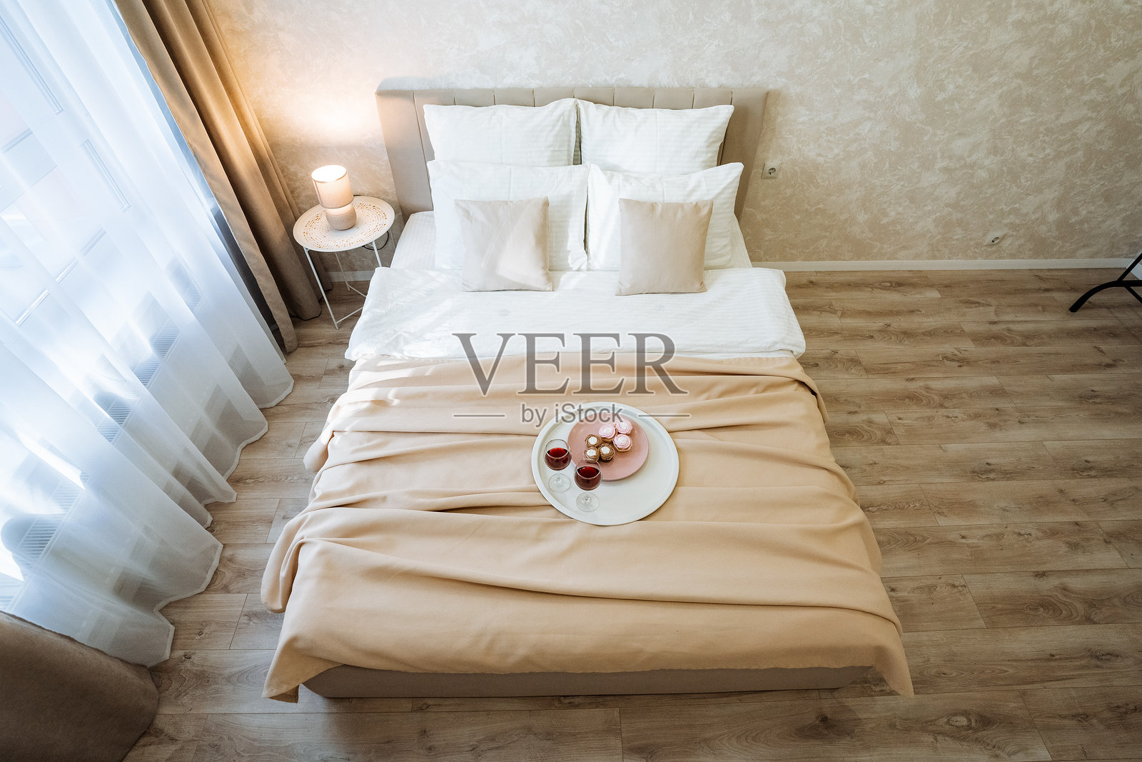 探索一个时尚现代的卧室,舒适的床上优雅地披着轻盈的布料,完美营造出宁静祥和的氛围。照片摄影图片