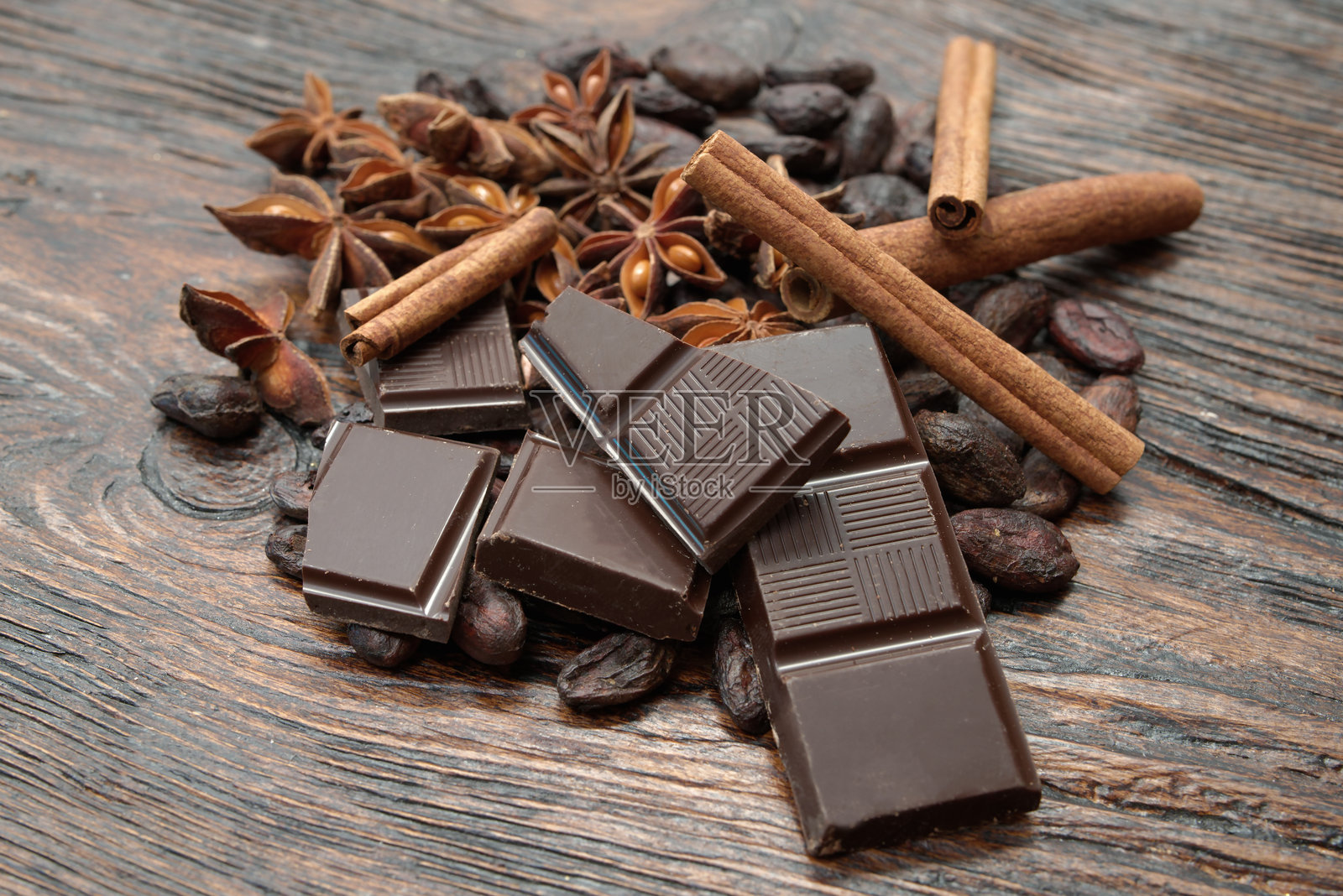 破碎的黑巧克力和可可豆放在桌子上照片摄影图片