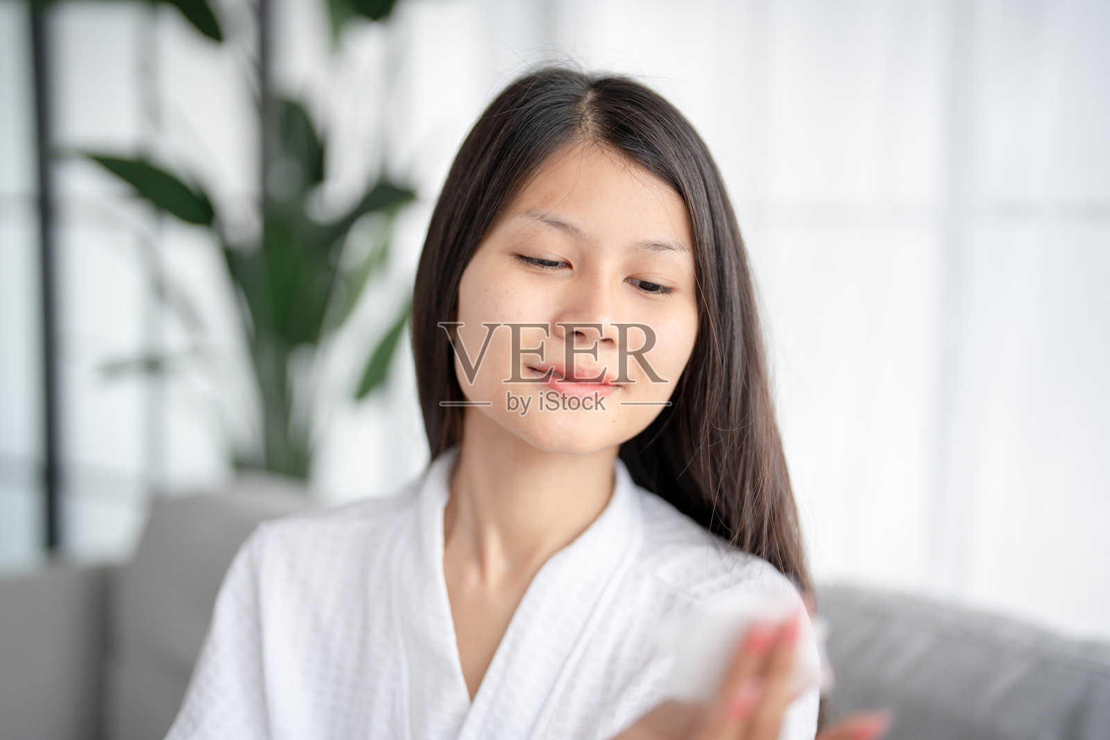 亚洲女性的日常美容程序,使用卸妆水清洁肌肤。照片摄影图片