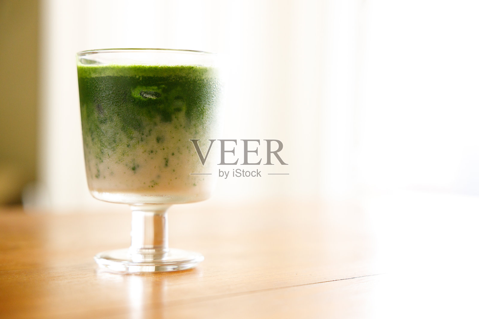 冰镇抹茶拿铁,正宗日本抹茶拿铁饮品装在玻璃杯中。照片摄影图片