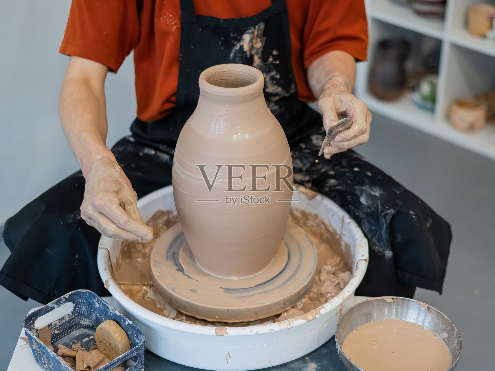 陶艺师的双手在陶轮上制作陶瓷花瓶的特写镜头。照片摄影图片