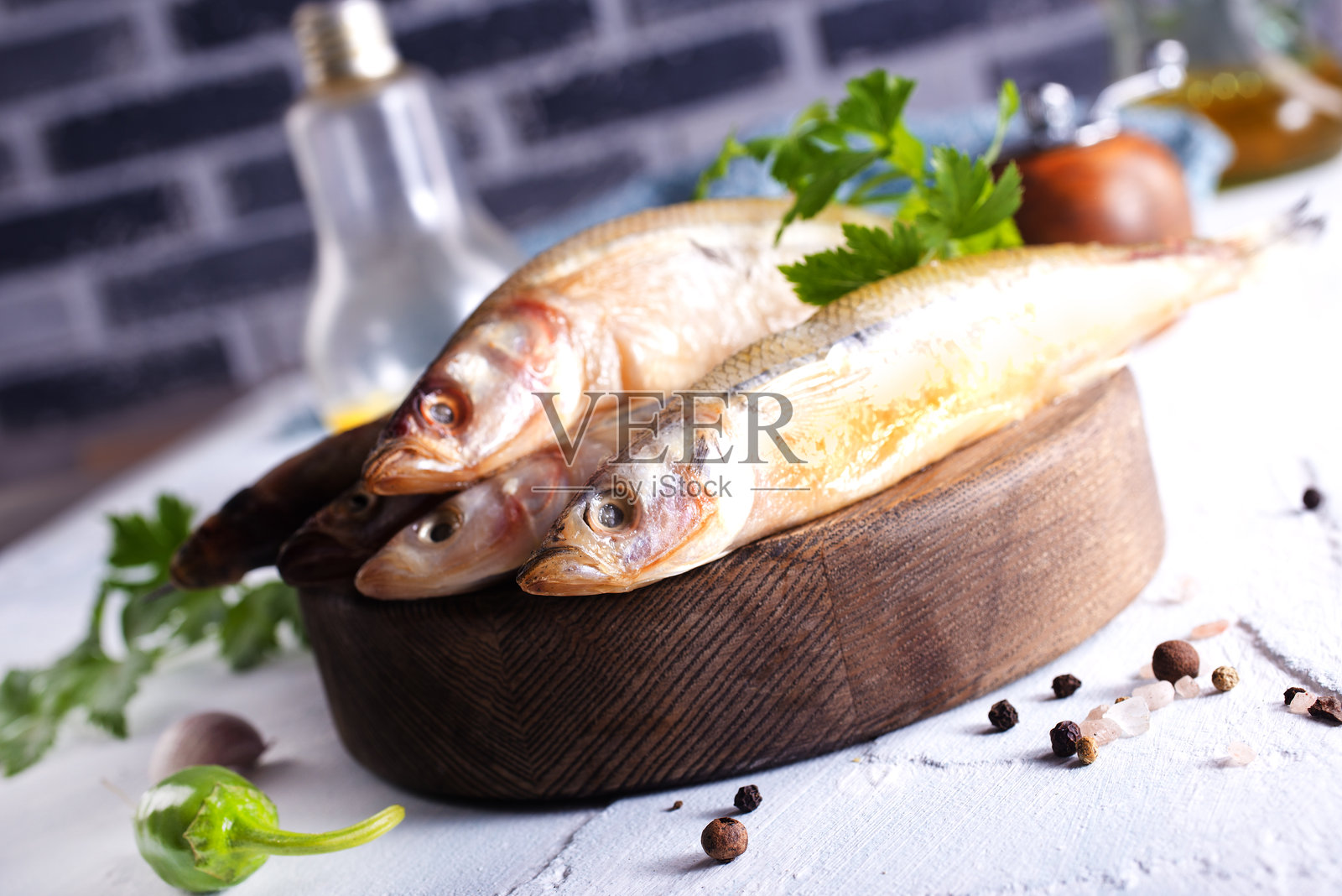 新鲜的鱼和香料放在白色桌子上照片摄影图片
